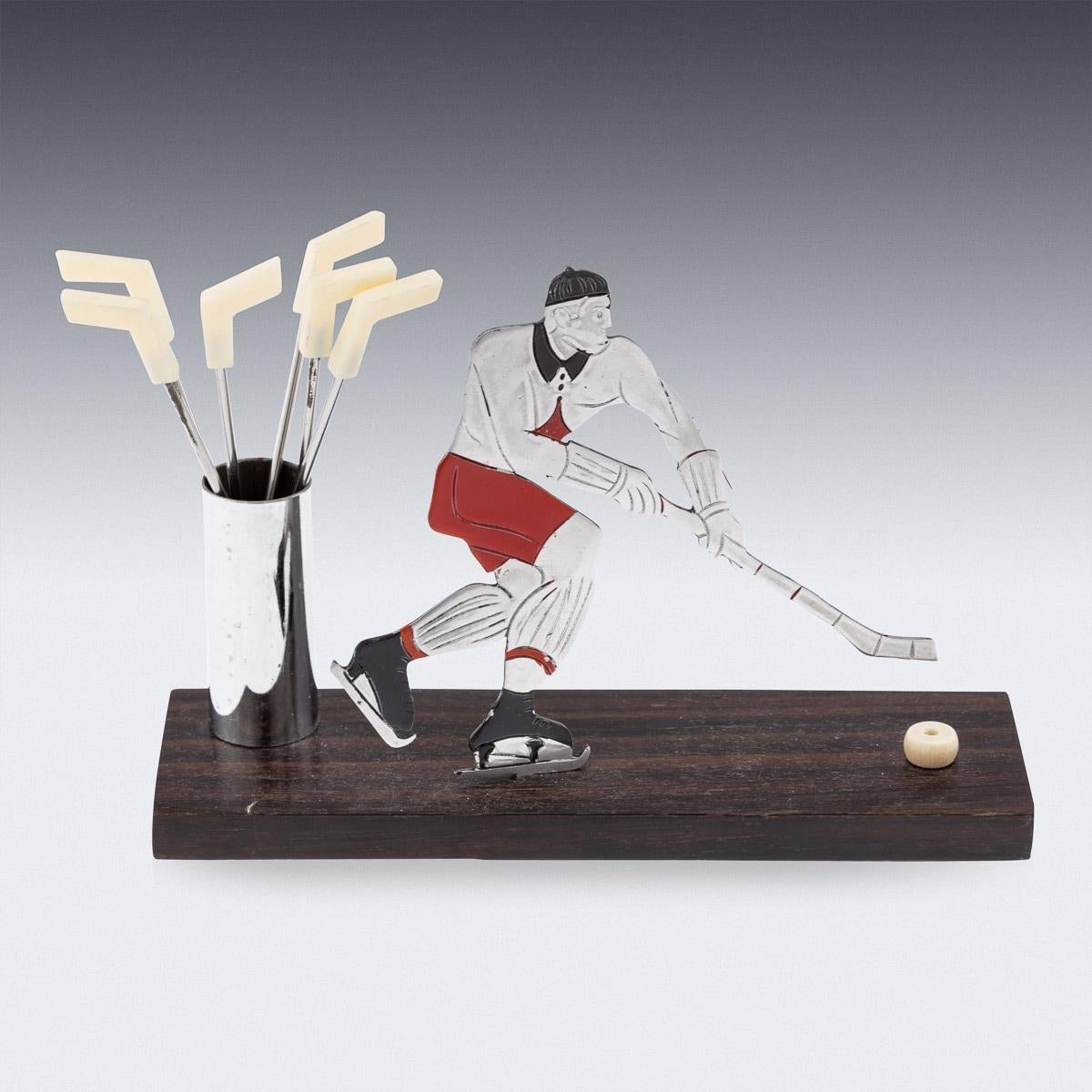 Antique 20th century Art Deco metal chrome plated & enamelled cocktail stick set, in the form of an ice hockey player, the 6 cocktail stick finials modelled as hockey sticks with celluloid finials. Just as the prohibition era was lifted in the USA