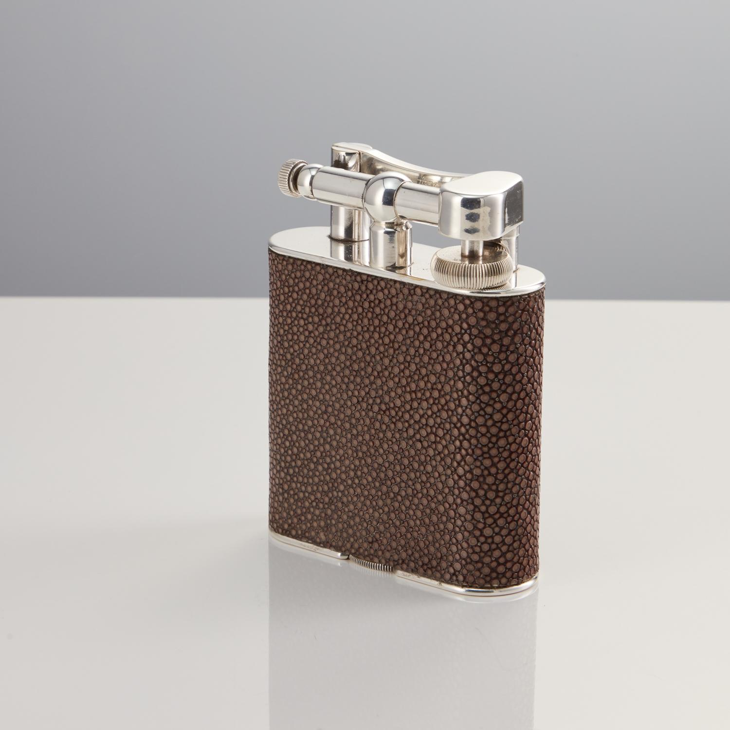 An attractive looking table lighter by Dunhill, in full working order. The beautiful muted coloured Shagreen is in perfect condition. The lighter feels great to hold and use. The piece has full patent marks and Dunhill logo, which is seen in the
