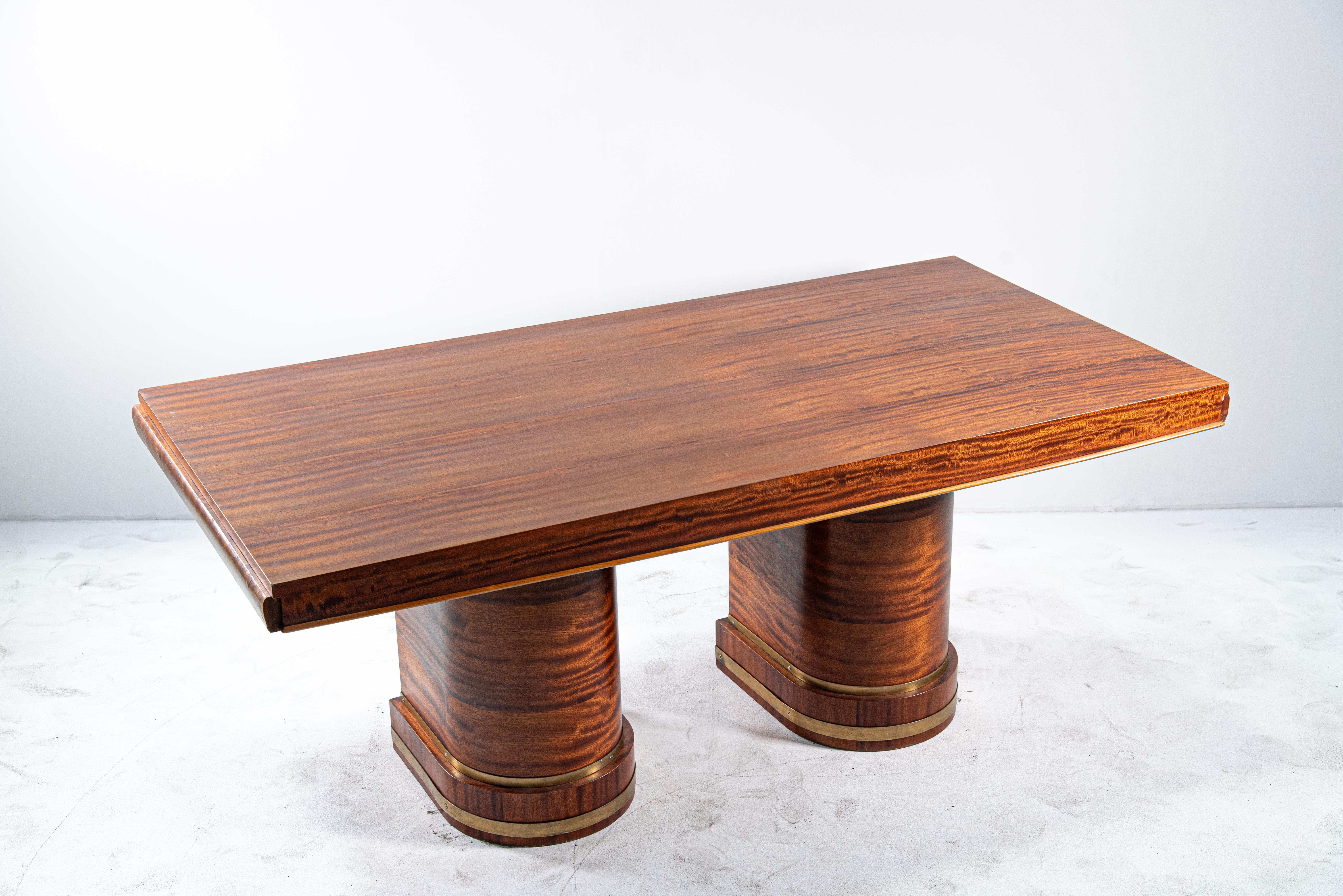 This stunning 20th Century Art Deco Flamed Mahogany Desk is a perfect blend of form and function, showcasing the luxurious style characteristic of the Art Deco era. The desk's rich flamed mahogany veneer captures the eye with its striking wood