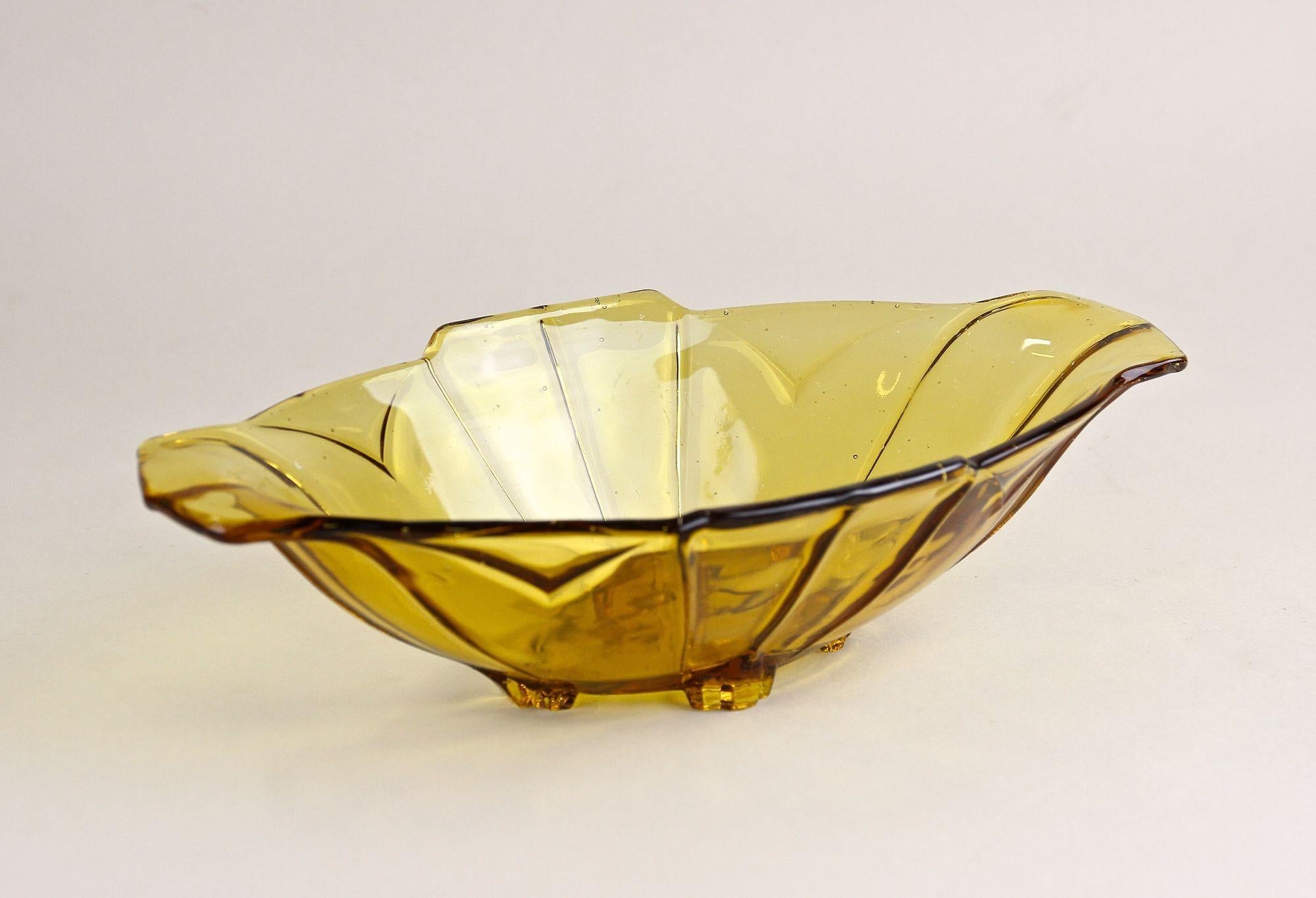 Lovely amber colored Art Deco glass jardiniere or glass bowl from the period around 1920 in Austria. Showing a fantastic yellow/brown color tone, this very decorative glass item impresses with a beautiful shape adorned by unique design elements. The