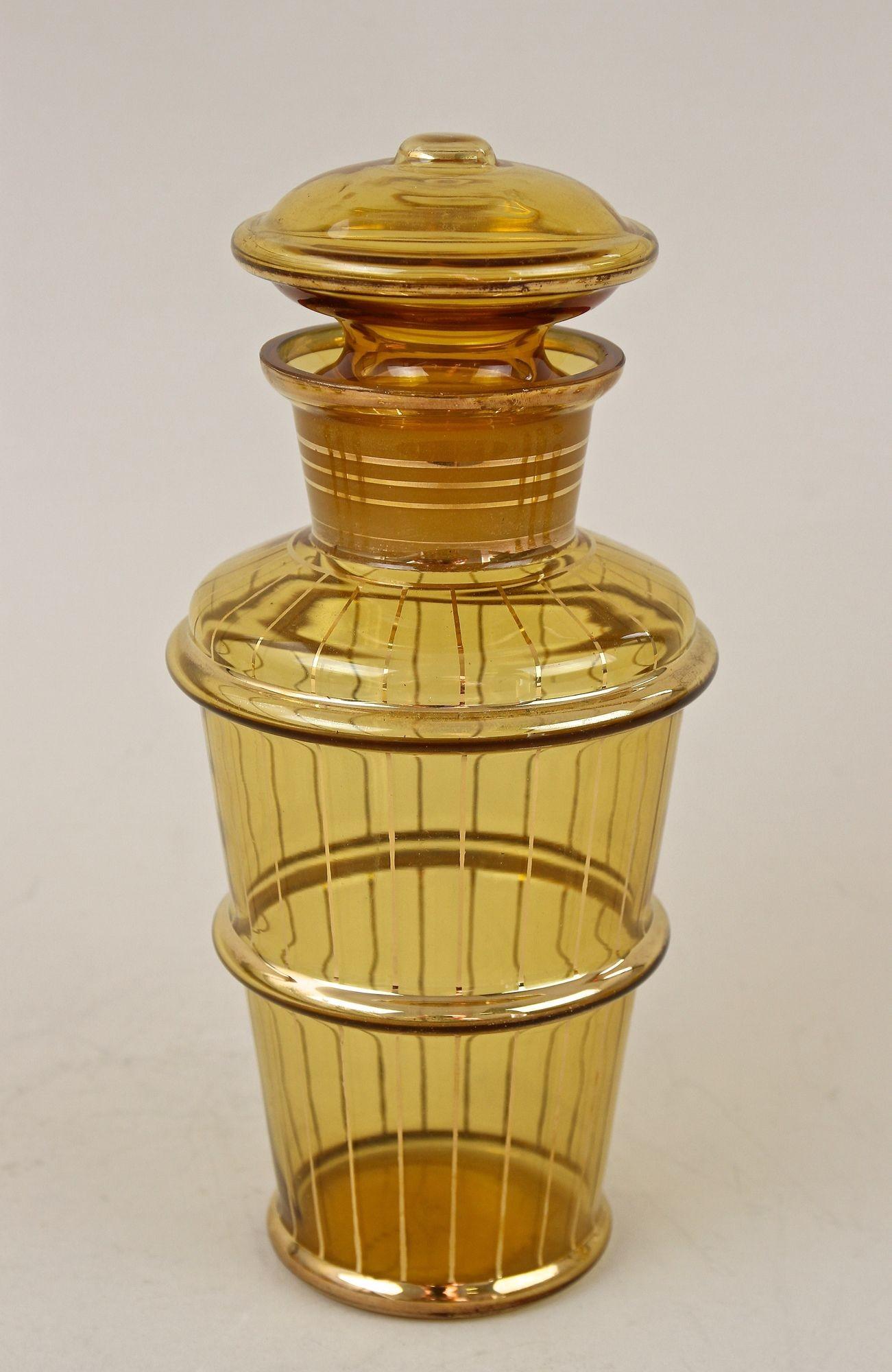 Noble amber-colored Art Deco glass decanter set of seven from the Art Deco period in the Czech Republic around 1920. Impressing with lovely gilt patterns, this outstanding designed Art Deco liquor/ decanter set consists of six fantastic shaped round