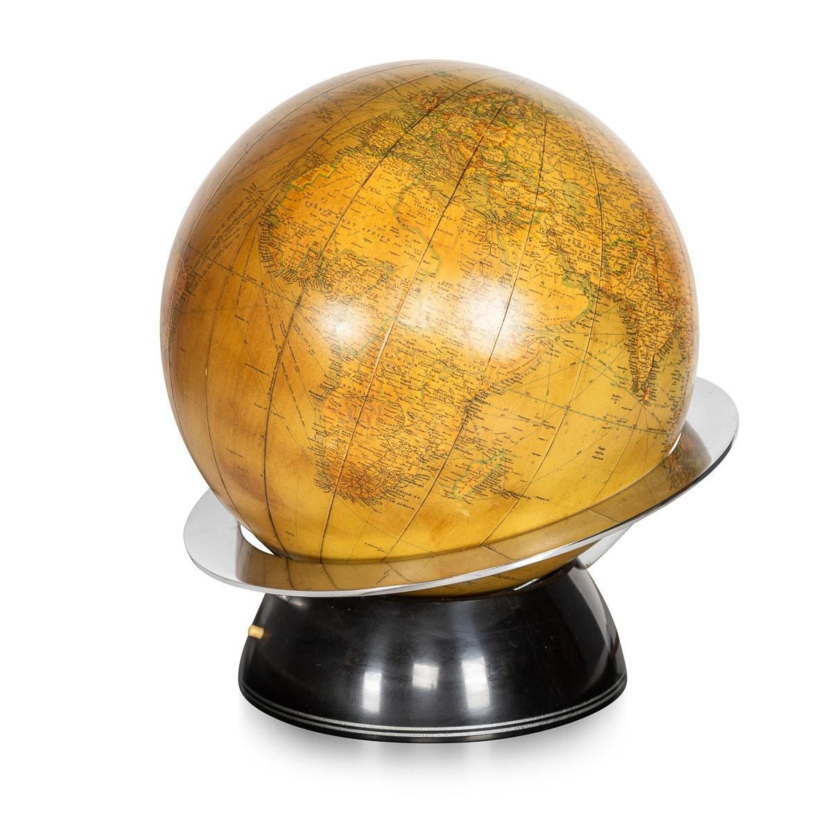 Crafted in Great Britain during the early 20th century, this extraordinary glass globe table lamp stands as a testament to rare and timeless design. The lamp showcases an elegant fusion of art deco aesthetics, boasting a polished metal and black