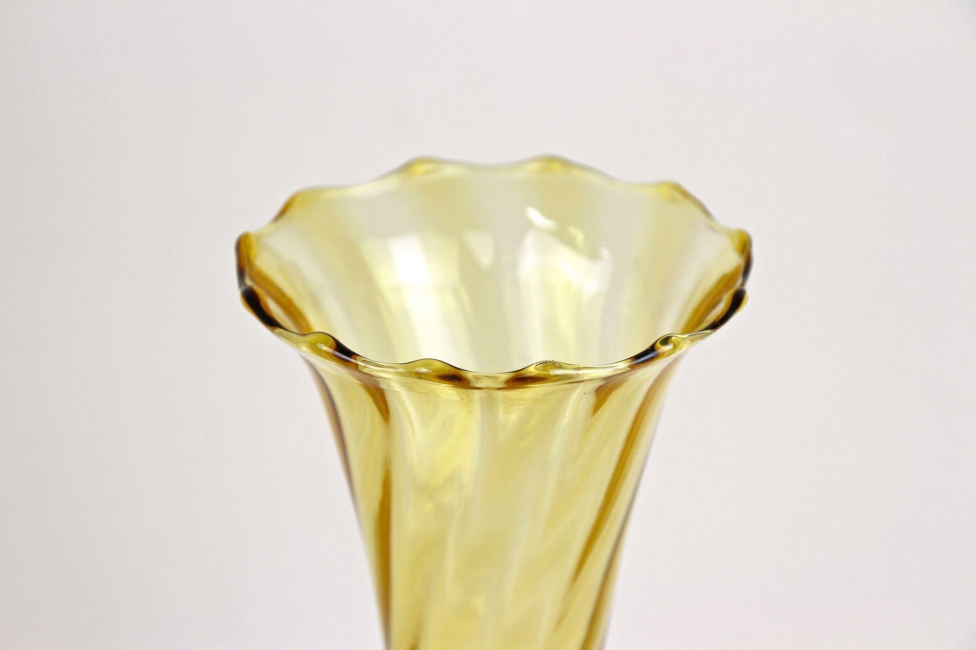 Delicate, amber colored Art Deco glass vase from the era around 1920 in Austria. Showing a beautiful yellow/brown tone, this decorative Art Deco glass vase impresses with its fantastic slim shaped 