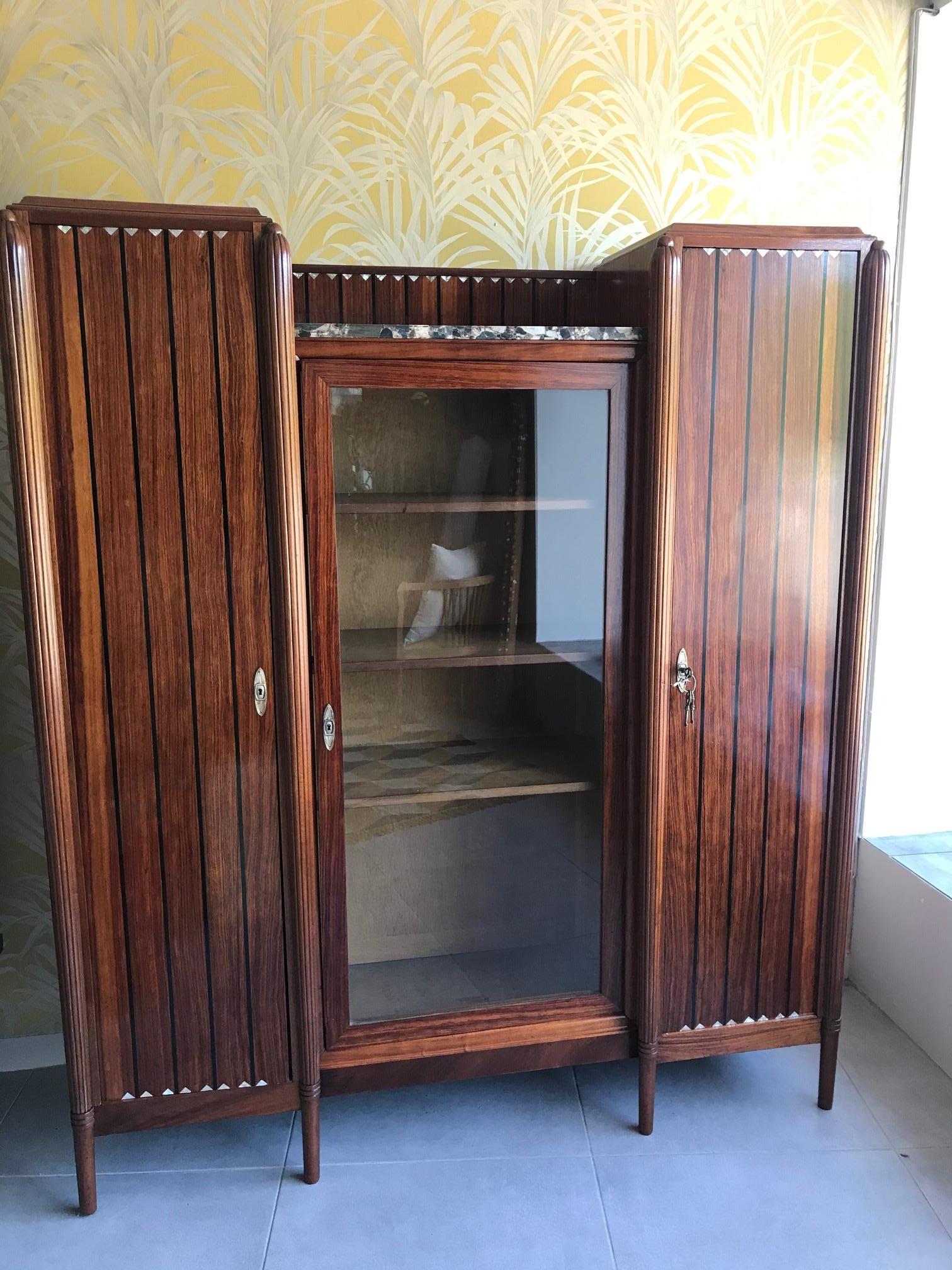 Beautiful and rare 20th century French Art Deco Macassar and mother of pearl inlaid vitrine from the 1930s.
Entirely removable and modular shelves. Two shelves parts and one vitrine part in the center. Removable marble on the top, ideal to show a