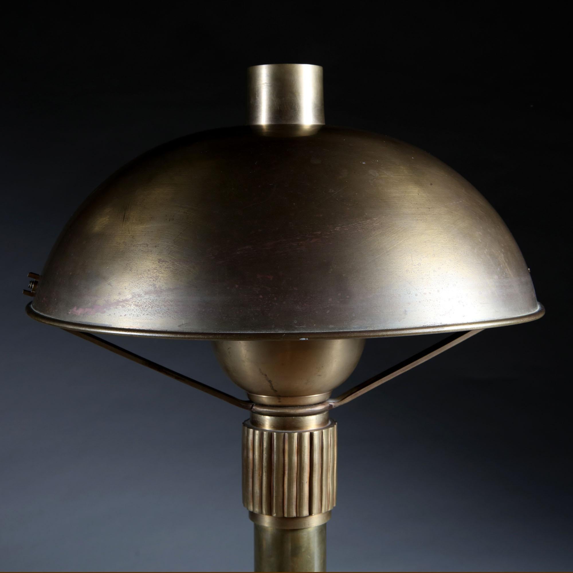 An Art Deco brass lamp with domed brass shade, with fluting to the top and base of the column, all supported on a circular base. Attributed to Perzel.

Perzel is a French lighting design house, originally founded by Jean Perzel in 1923, after having