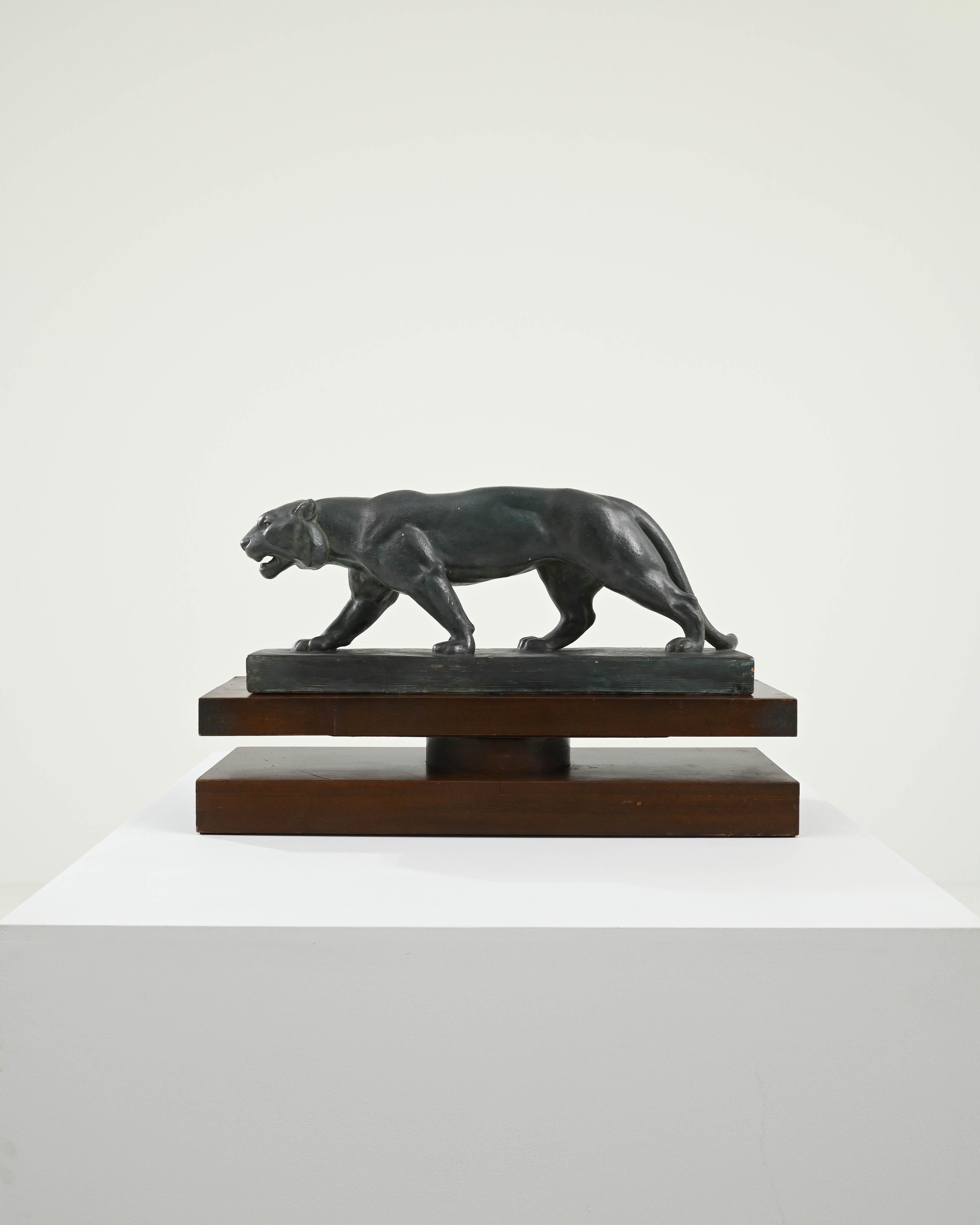 This elegant vintage plaster sculpture depicts a jaguar in motion; head slightly lowered, placing one foot in front of the other with perfect equilibrium. Built in France in the 20th century, the design reflects the Art Deco movement’s fascination