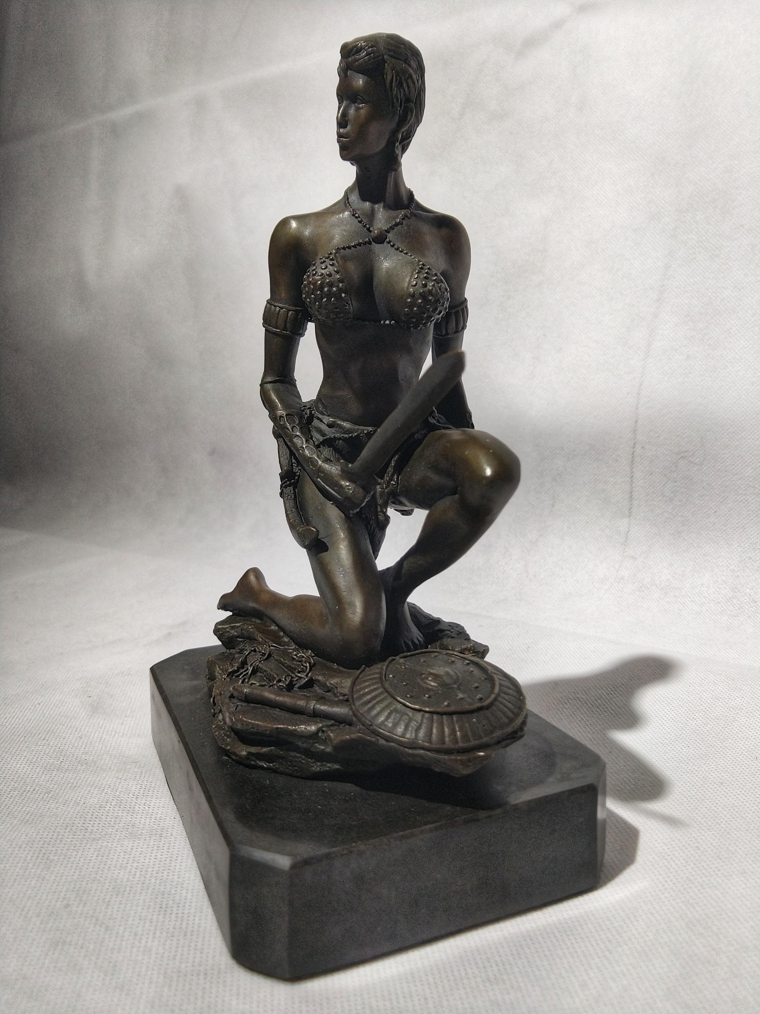 Beautiful Art Deco style sculpture depicting an Amazon warrior kneeling holding her sword, at her feet a chain and a shield. Signed Fisher.

Made using hot cast and the lost wax method: plum bronze, the purest form of bronze. This method was