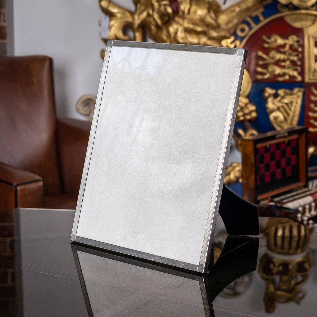20th Century Art Deco silver & engine turned photograph frame, with stylised corners, mounted on an ebonised easel support and set with glass.
Hallmarked English silver, Birmingham, year 1950 (A), Maker S&M (Sanders & Mackenzie).

Condition
In