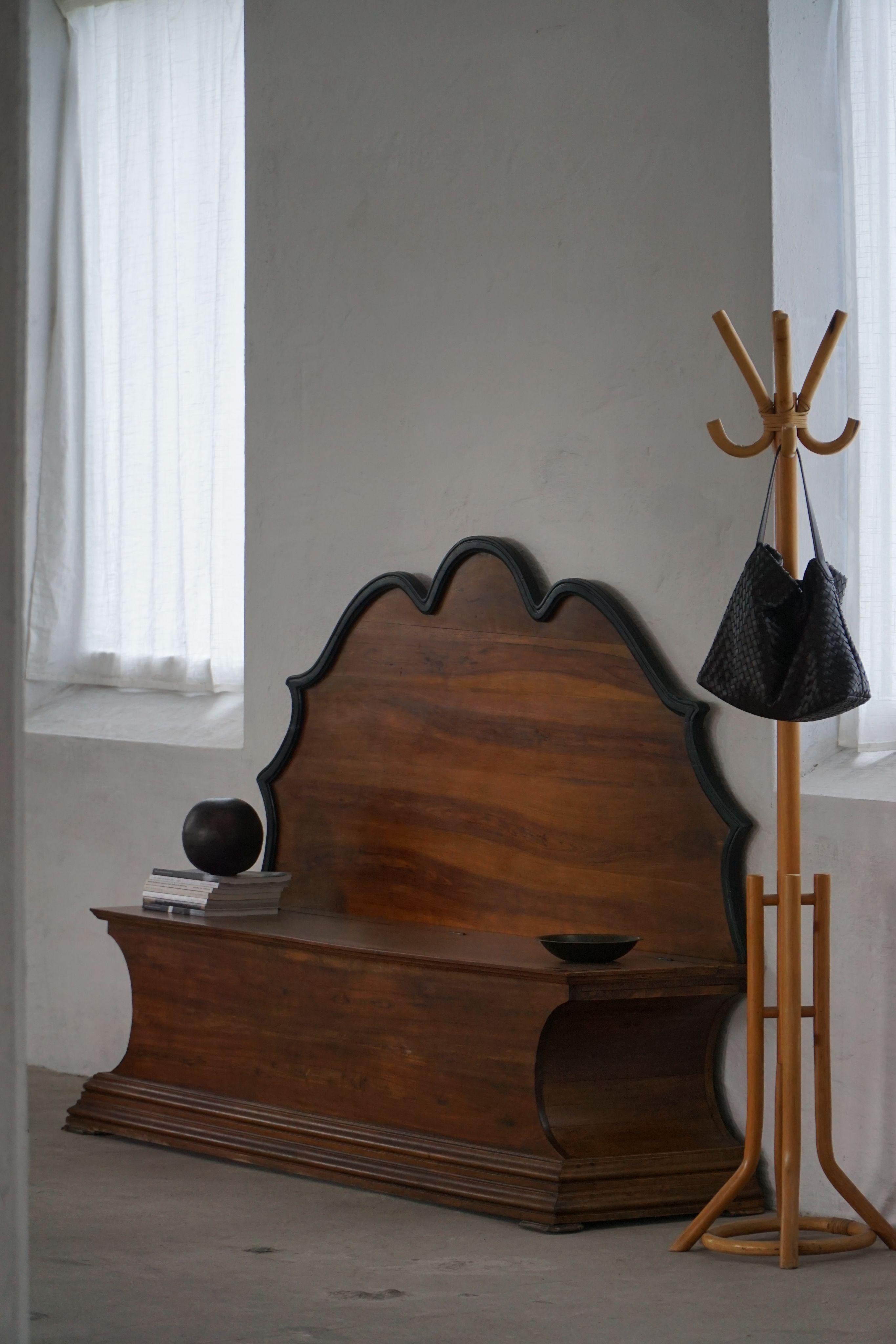 Magnifique banc de rangement Art déco danois du XXe siècle, fabriqué en bois de noyer avec une patine naturelle et chaleureuse. Le design allie la fonction à un sens raffiné des proportions - le dossier incurvé et architectural souligné de peinture