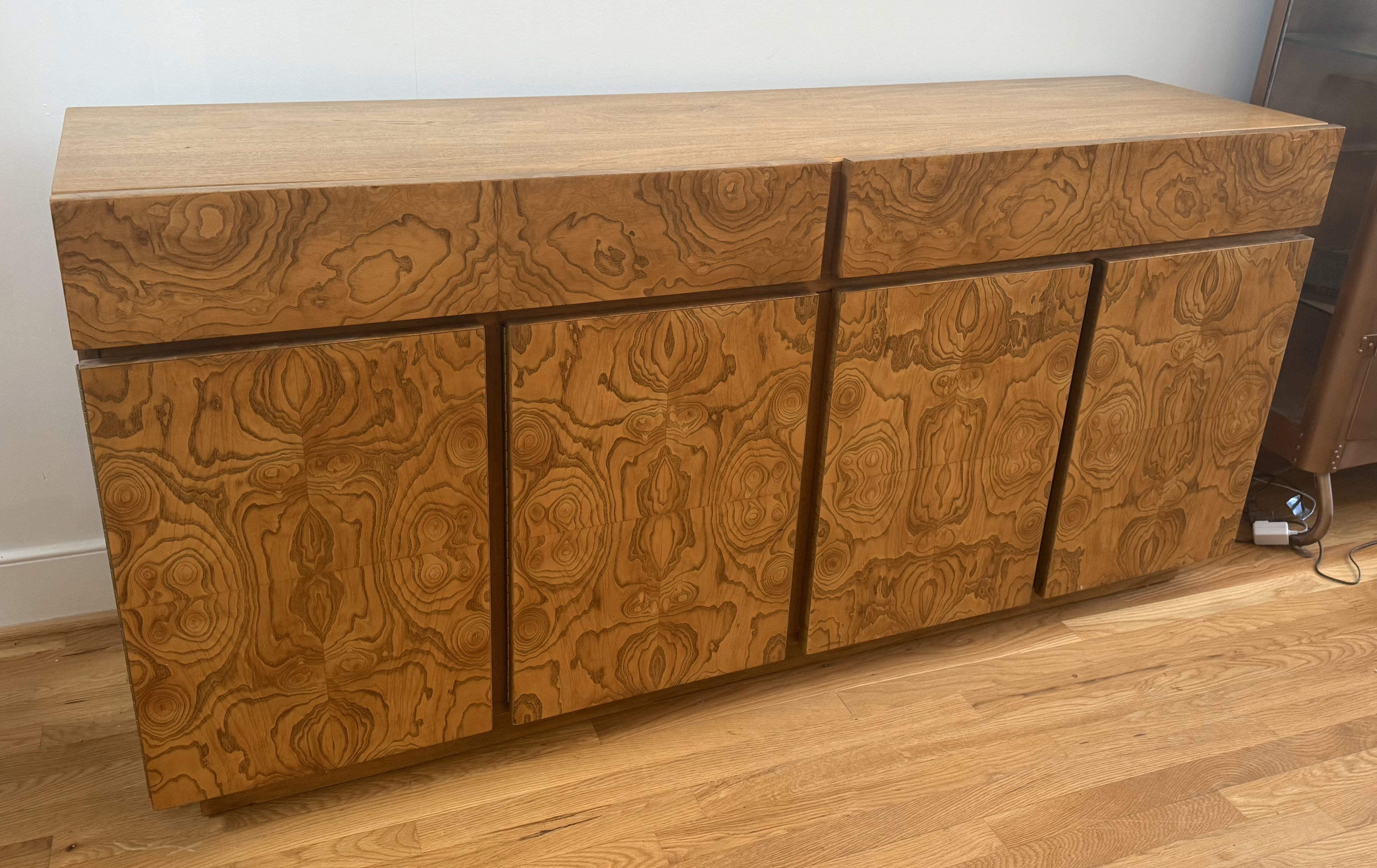 Ein außergewöhnliches Beispiel amerikanischer Handwerkskunst mit Art-Déco-Einfluss! Diese schöne Anrichte wurde um 1970 in Virginia hergestellt. Das Möbelstück ist aus reich gemasertem Eschenfurnier gefertigt und zeigt dramatische, symmetrische
