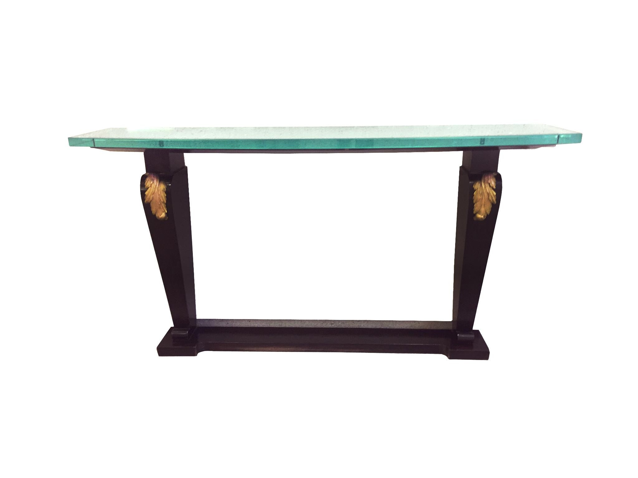 An elegant console table comprising of an ebonized wood base and a glass tabletop. Structurally, the base is designed with two column legs fastened together with a stretcher base, while the glass top curves outward at the front and cut straight at