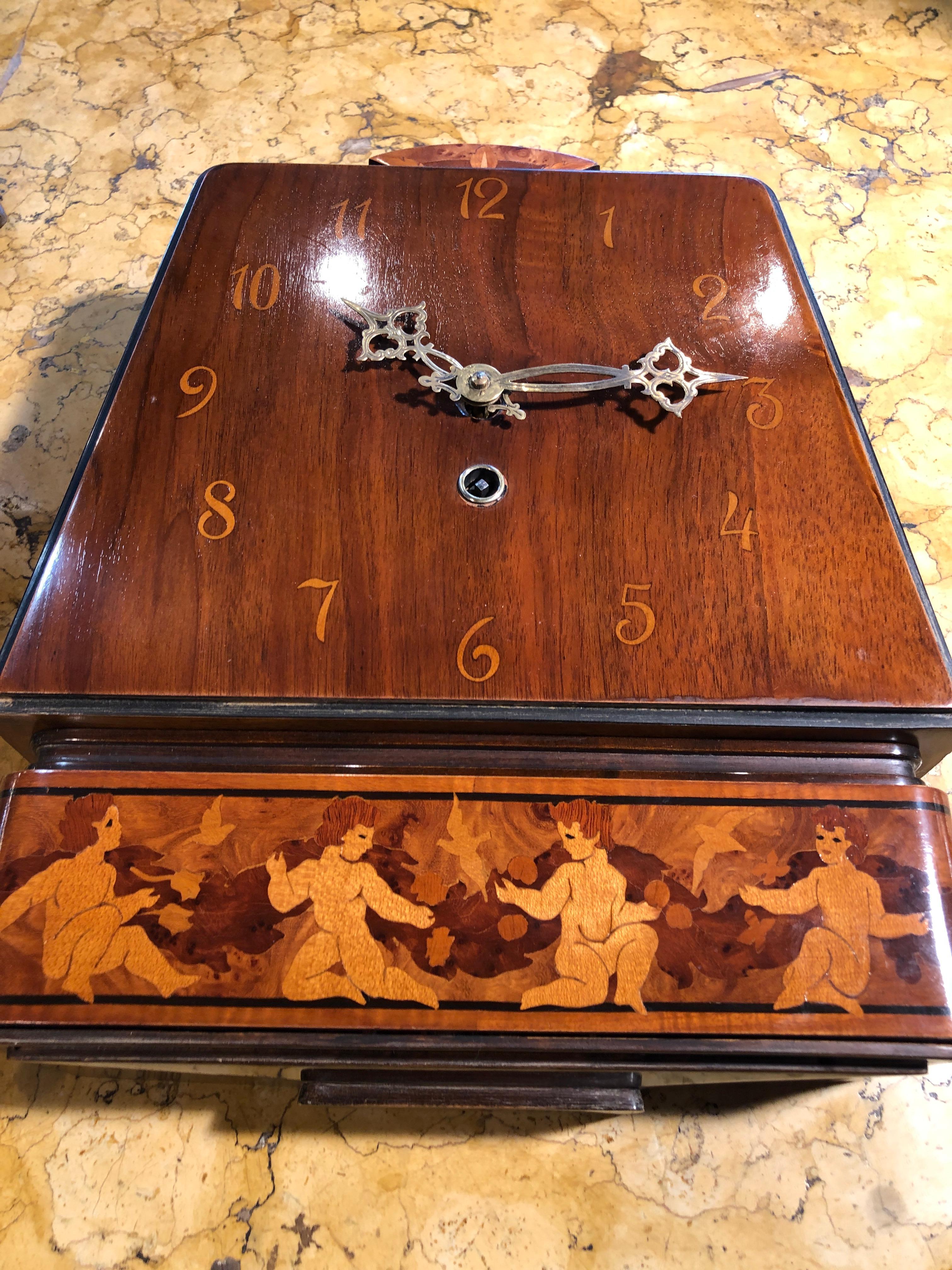 Wall clock from Sweden, the deco period, circa 1940s, in exceptional functional aesthetic conditions.
In walnut and walnut briar, it presents boxwood inlays with floral motifs and also representing four small angels. The mechanism works and the