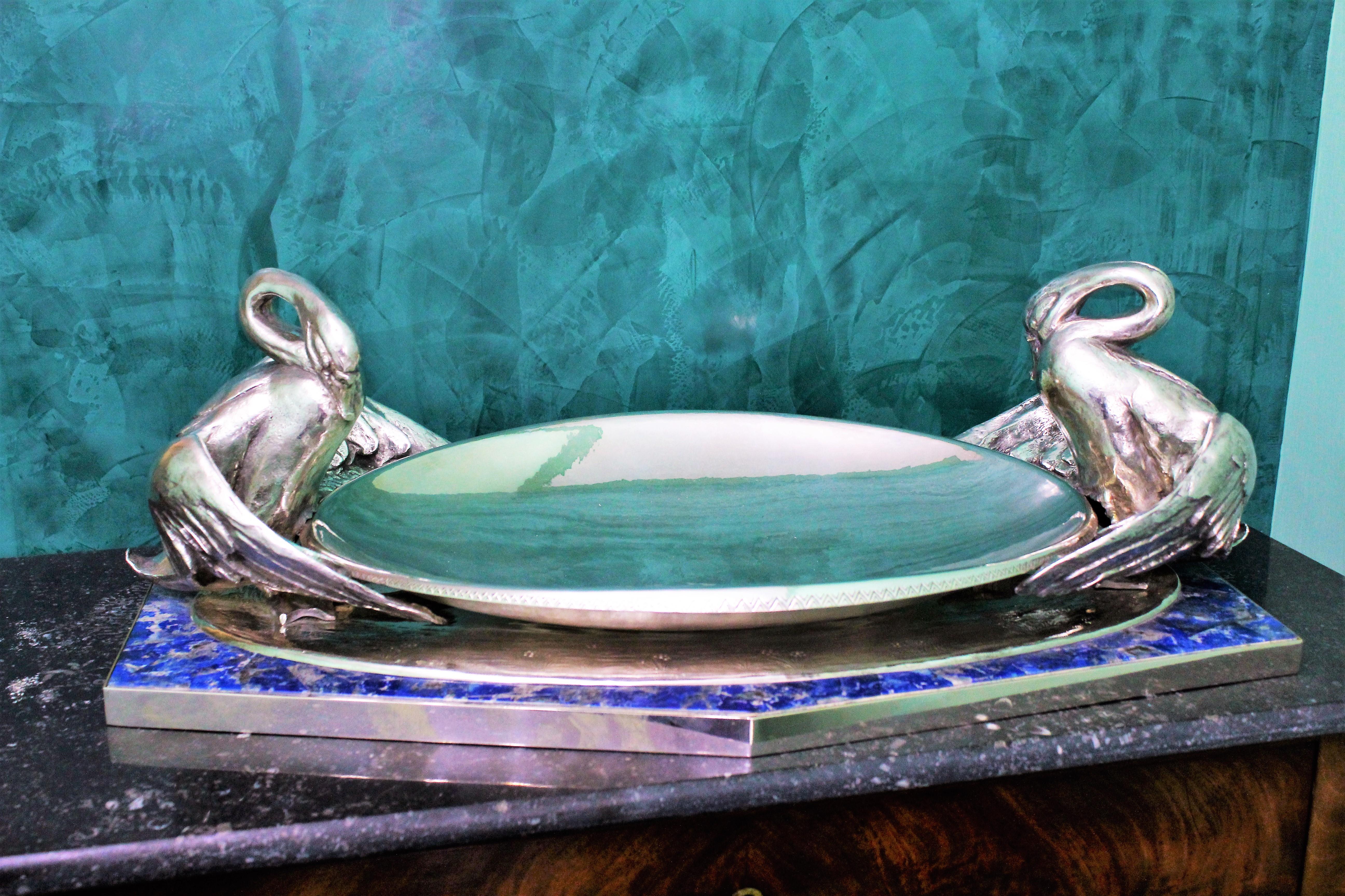 Italian Art Nouveau artistic silver centerpiece composed by oval hammered tray with geometrical engraved border and with two opposed engraved cast swan sculptures, all lying upon an esagonal silver base chiseled with grass and flowers motives and
