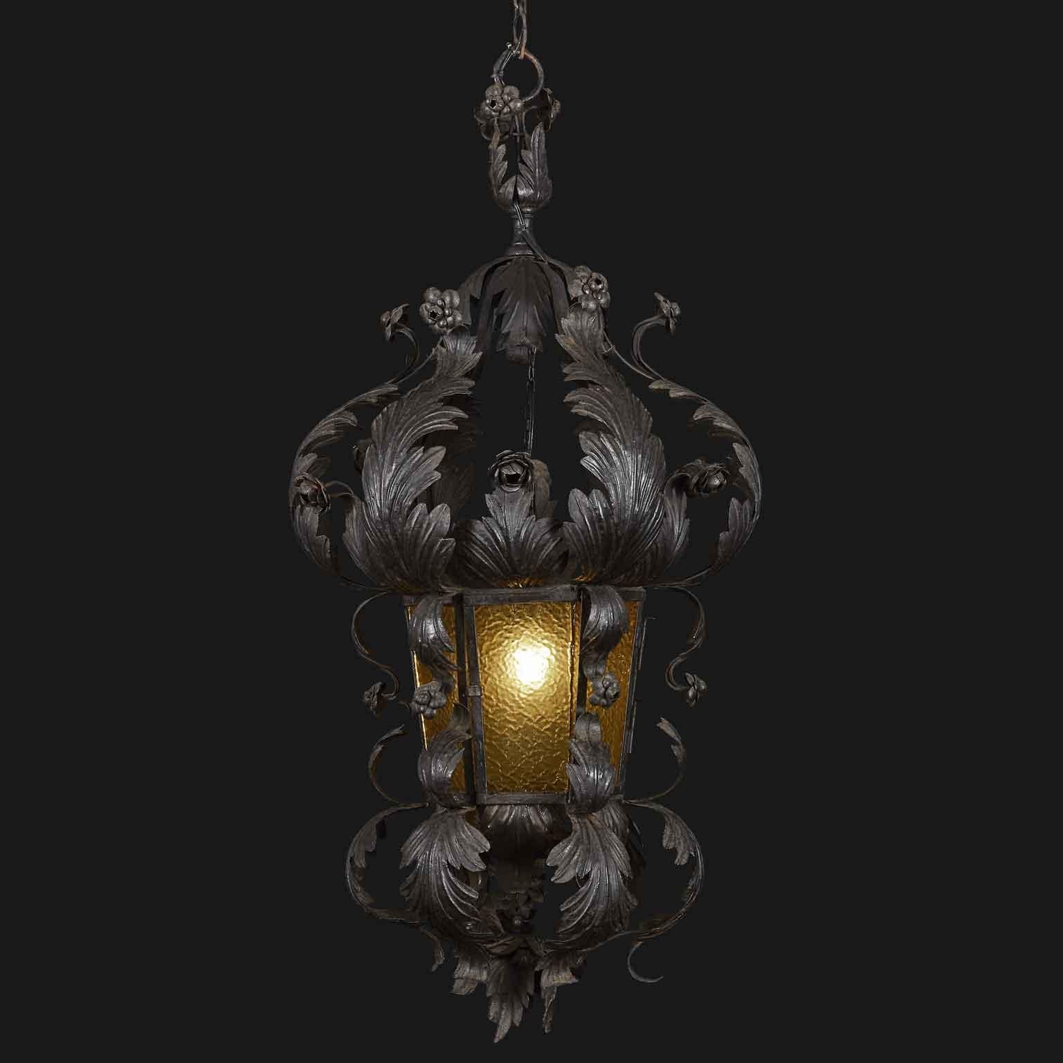 A floral Art Nouveau wrought iron lantern from Italy, with circular vertical foliate structure centered by an hexagonal shaped cage with original cathedral amber glasses. One Edison 27 light. Good working condition. 
This Italian hand forged wrought