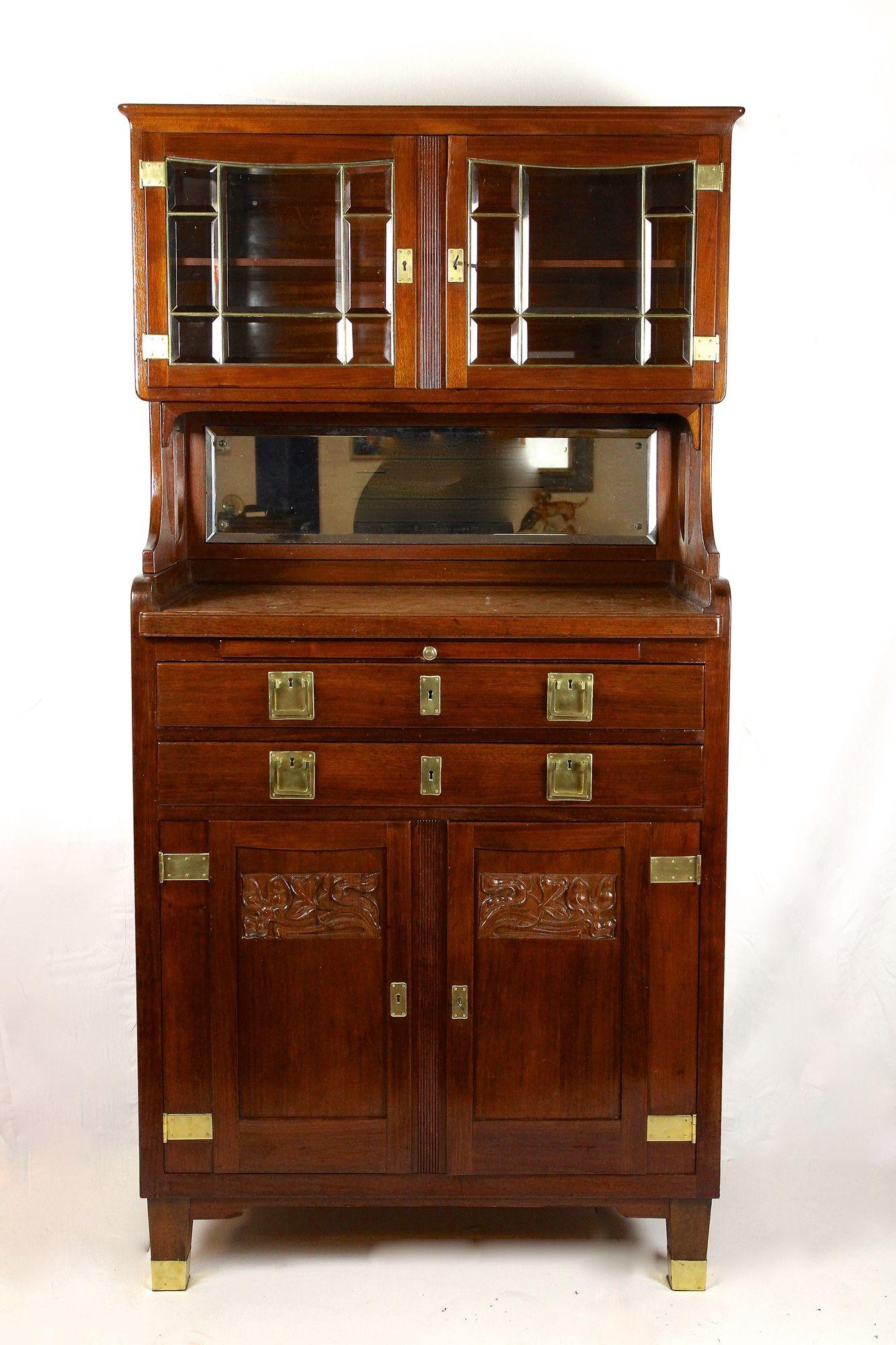 Absolutely beautiful, rare Art Nouveau mahogany buffet cabinet out of Austria around 1910. Consisting of two parts, the extraordinary designed lower part impresses with lovely floral themed carvings in the two doors and provides two additional