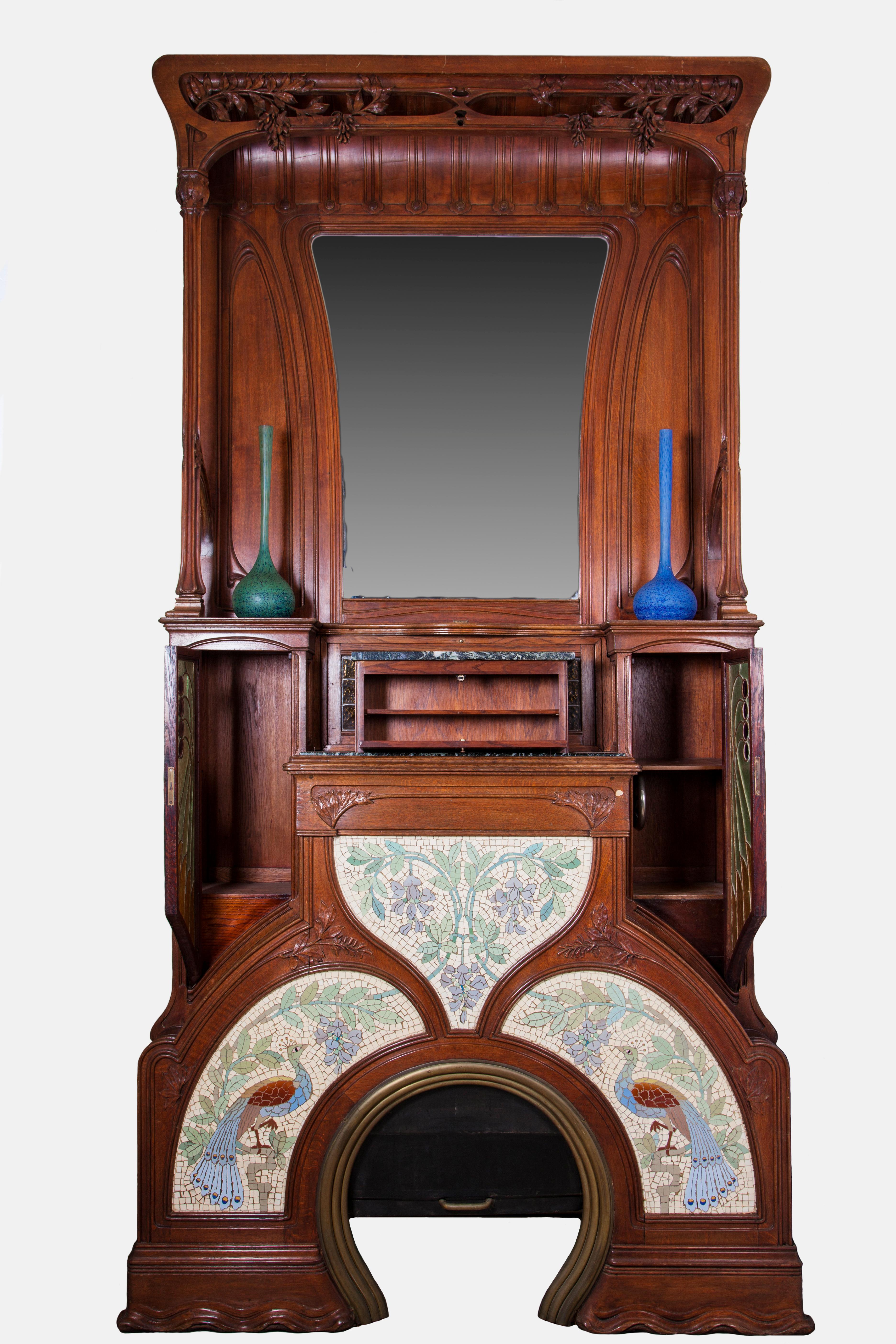 Majestic Catalan Art Nouveau fireplace inspired by the artistic current of Gaudi.
Central part is decorated with naturalistic figures on colored ceramic tiles, typical of the Art Nouveau.
The lead-colored cathedral glass embellishes the central