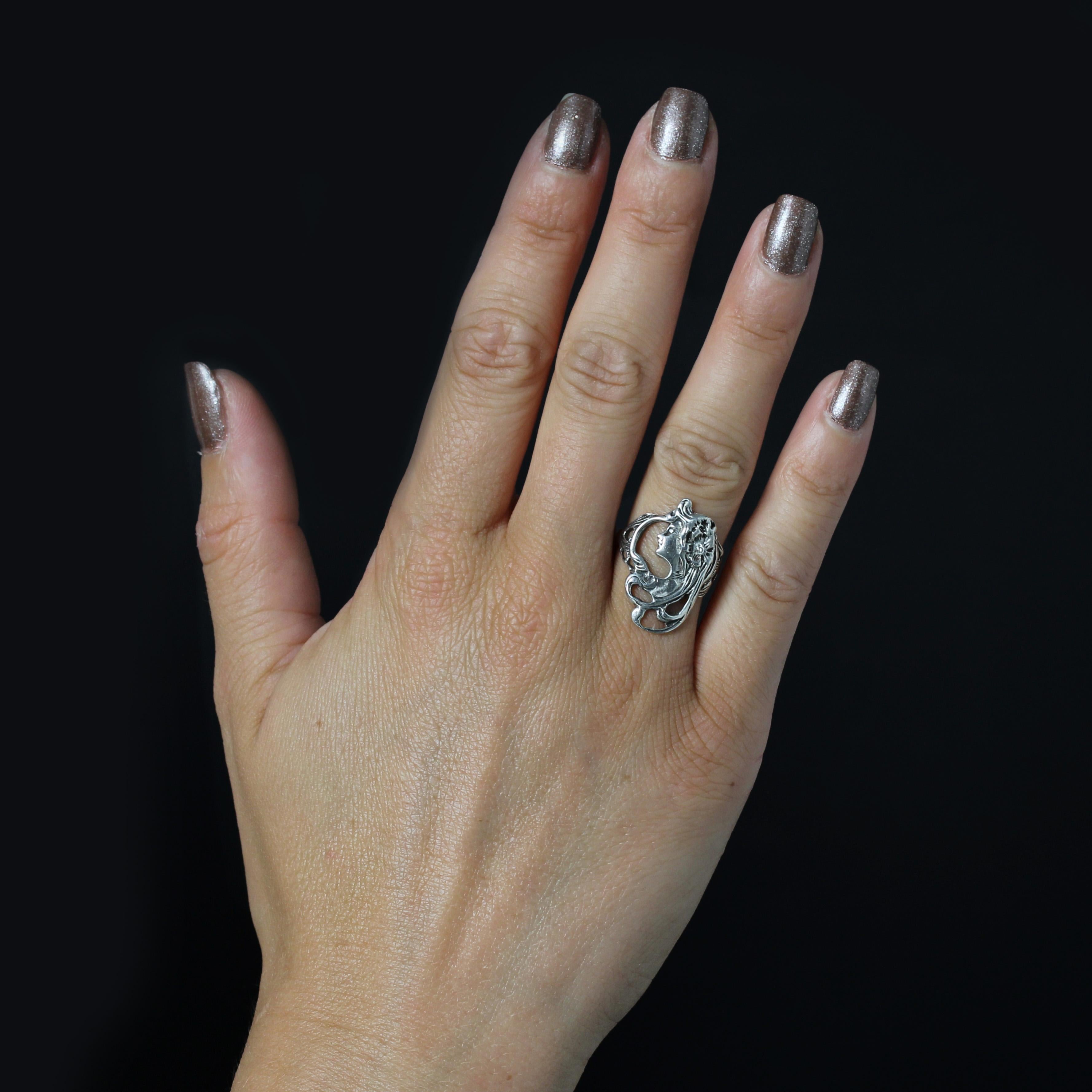 Bague en argent.
Très plate et épousant la courbe du doigt, cette jolie bague en argent ancien présente un profil de femme dans un motif végétal ajouré.
Hauteur : 2,5 cm environ, largeur : 18,5 cm environ, épaisseur : 1,4 mm environ.
Poids total du
