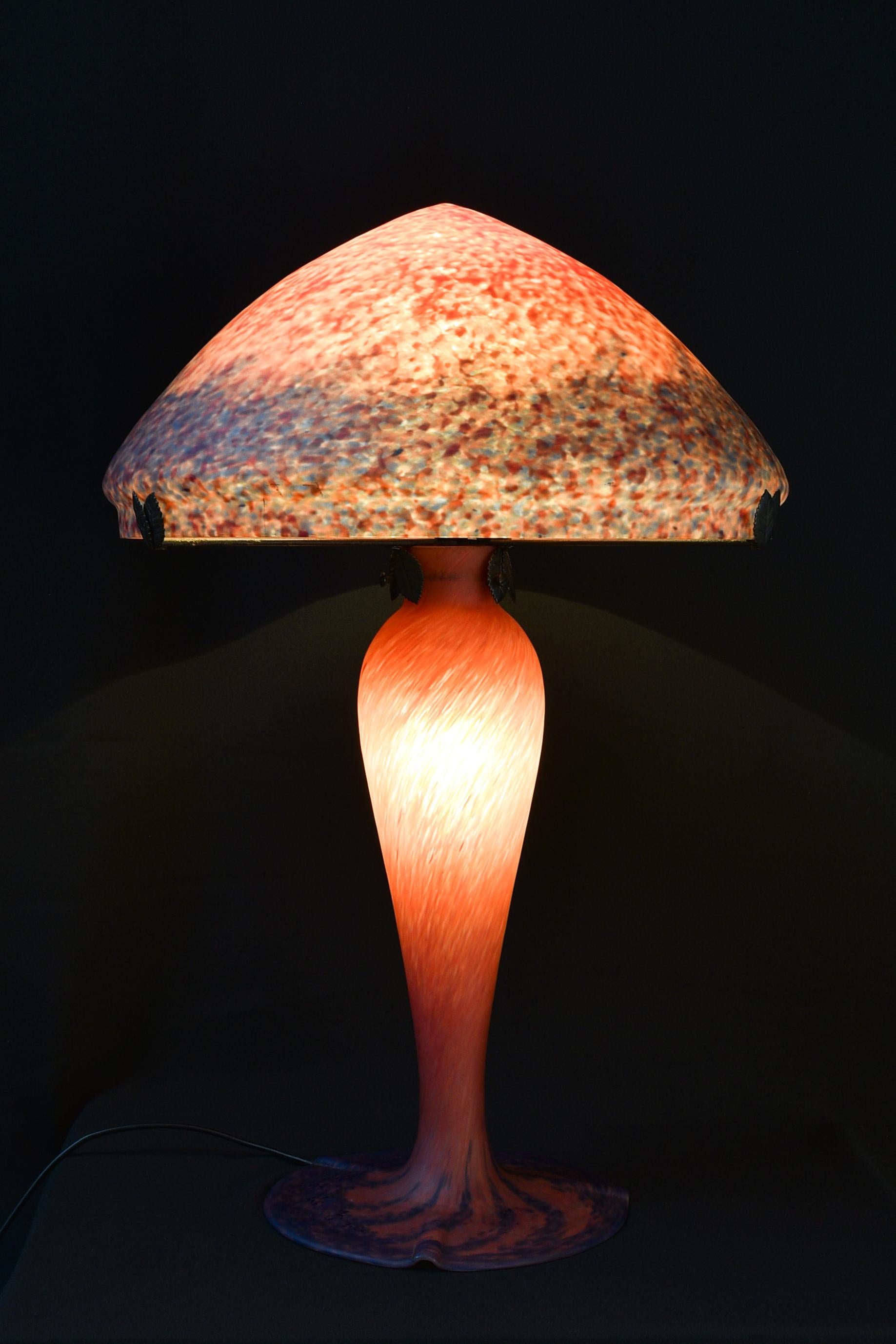 Art Nouveau table lamp by Art de France. Big mushroom lamp in beautiful vivid orange and violet mottled glass. Signed 'Art de France' both on the lampshade and foot. 