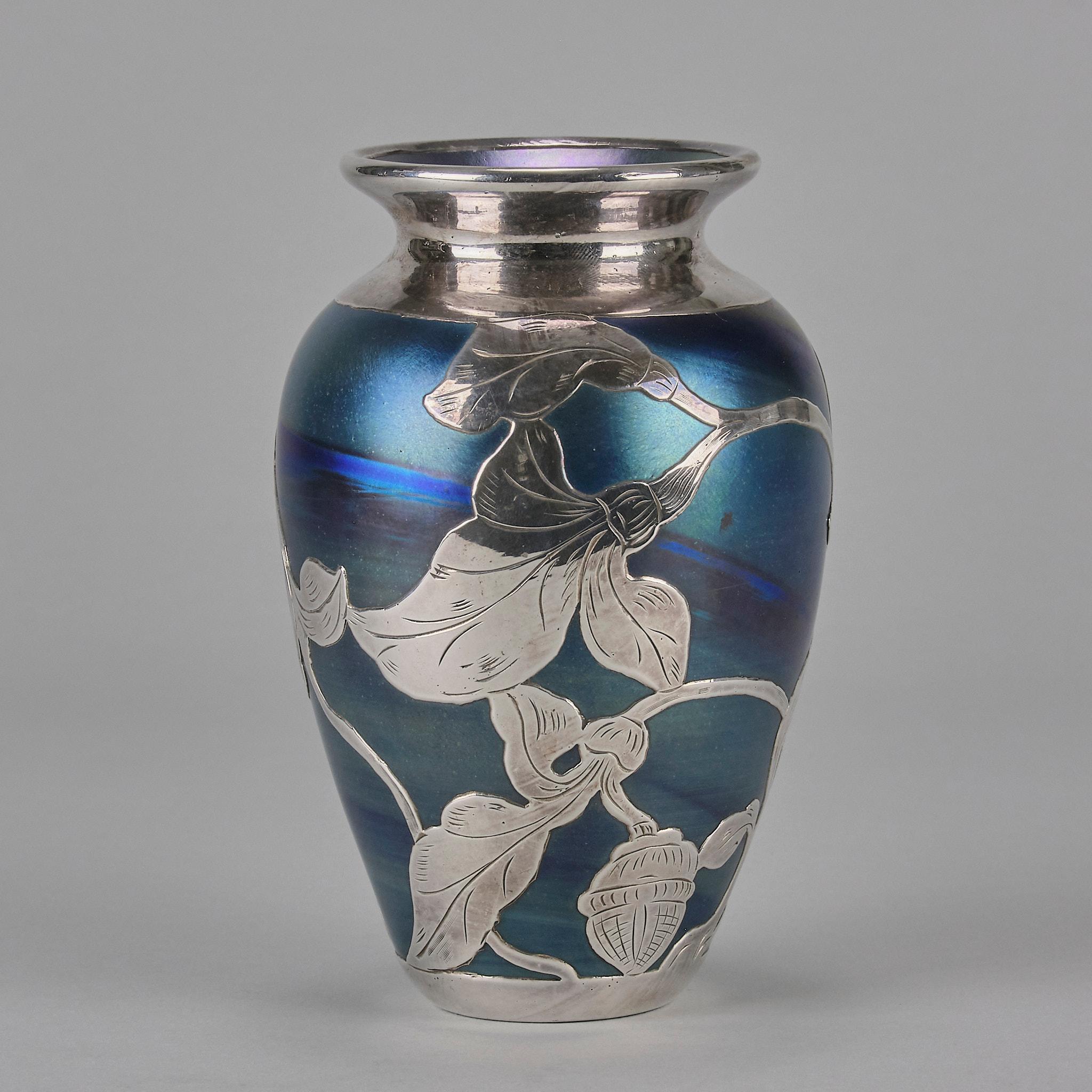 An excellent early 20th Century Austrian Art Nouveau iridescent petrol blue glass vase, decorated with an applied silver organic floral pattern around the full circumference of the body.
ADDITIONAL INFORMATION

Height: 15 cm 

Diameter: 10 cm