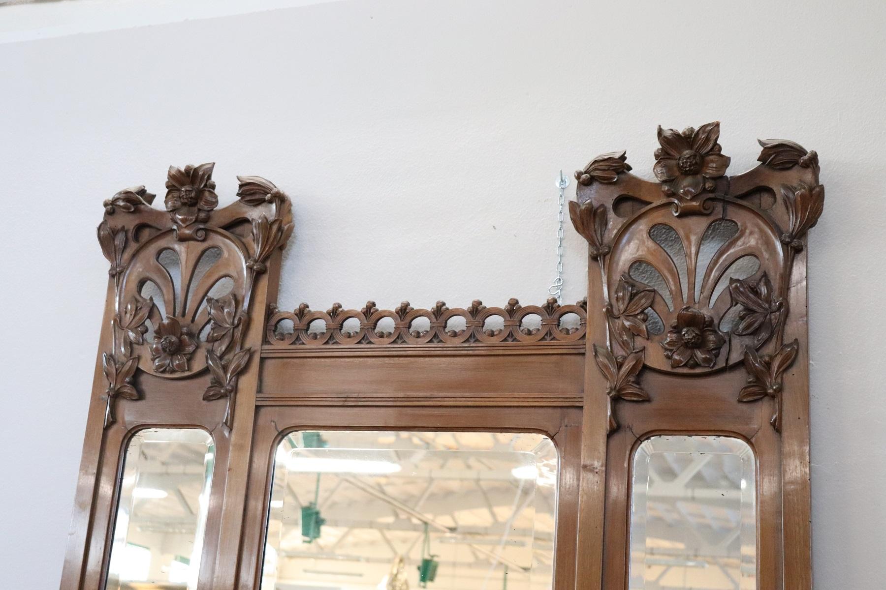 Important and rare antique mirror full period liberty, circa 1920. The mirror is made of solid walnut with a refined carving of floral taste typical of this era. In the lower part a planter compartment for storing vases. This type of mirrors were