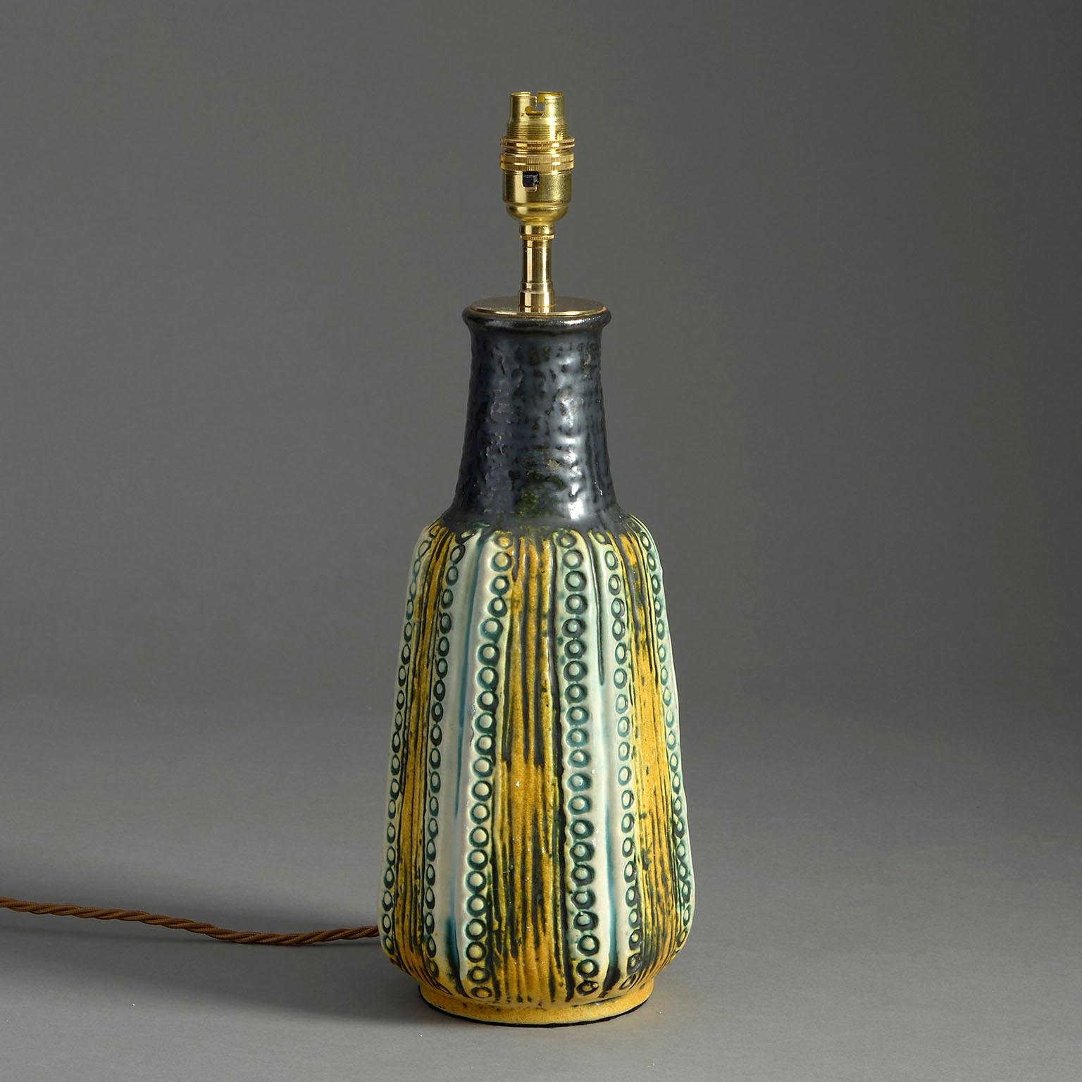 A mid-century art pottery vase, naturalistically modelled in black, green and yellow glazes.

Dimensions refer to ceramic elements.

Wired to UK standards. This lamp can be re-wired to all international specifications inclusive of