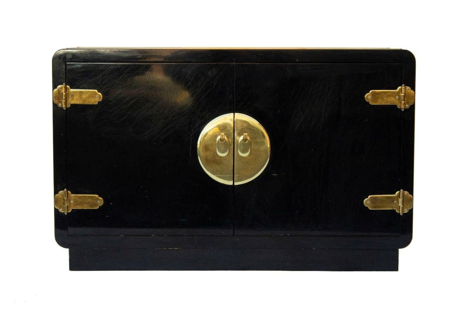 20th century modern Asian inspired black lacquered buffet or cabinet by Mastercraft. Two door designed cabinet with brass trim and details. One interior shelve.