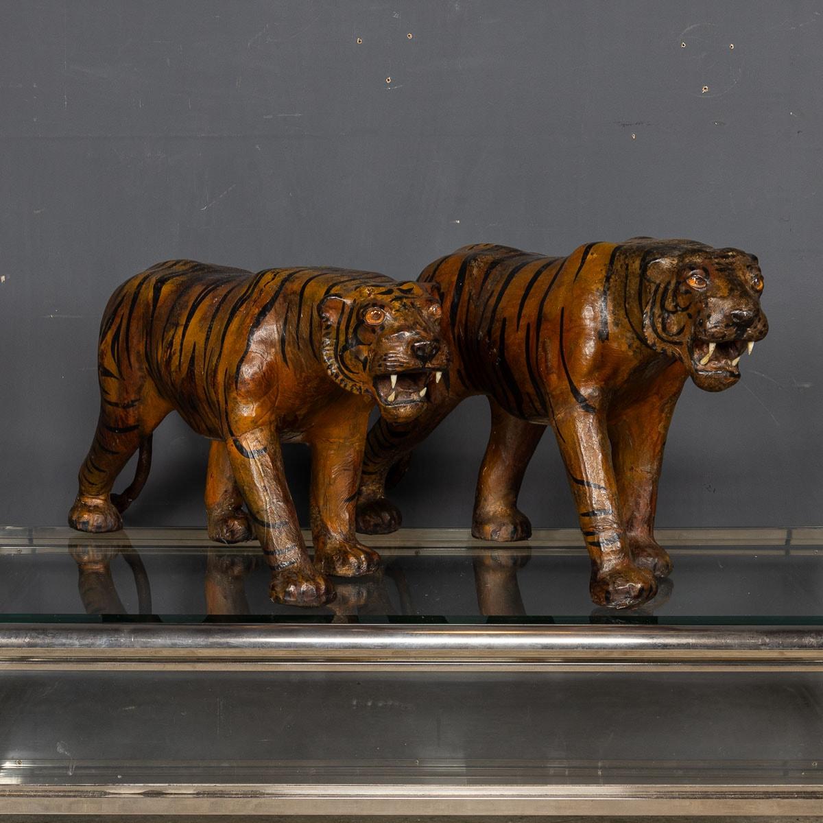 A distinctive duo of Asian tigers, crafted from molded leather and meticulously hand-painted with lifelike glass eyes, made during the 1920's.

CONDITION
In Great Condition - please refer to photographs.

SIZE
Height: 39cm
Width: 70cm
Depth: 20cm