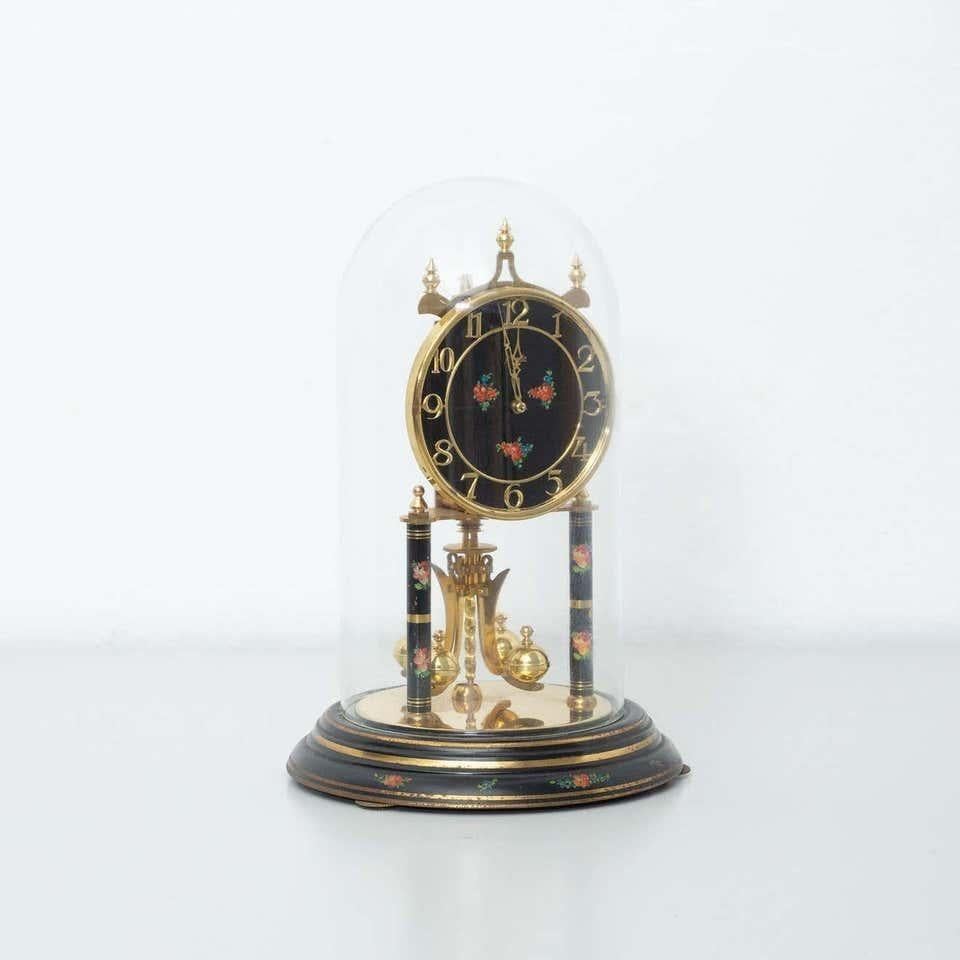 20th century Aymos Kendo table clock  By unknown manufacturer from Germany, circa 1950.    In original condition, with minor wear consistent with age and use, preserving a beautiful patina.    Material:  Metal  Wood    Dimensions:  ø 20 cm x H 29.5