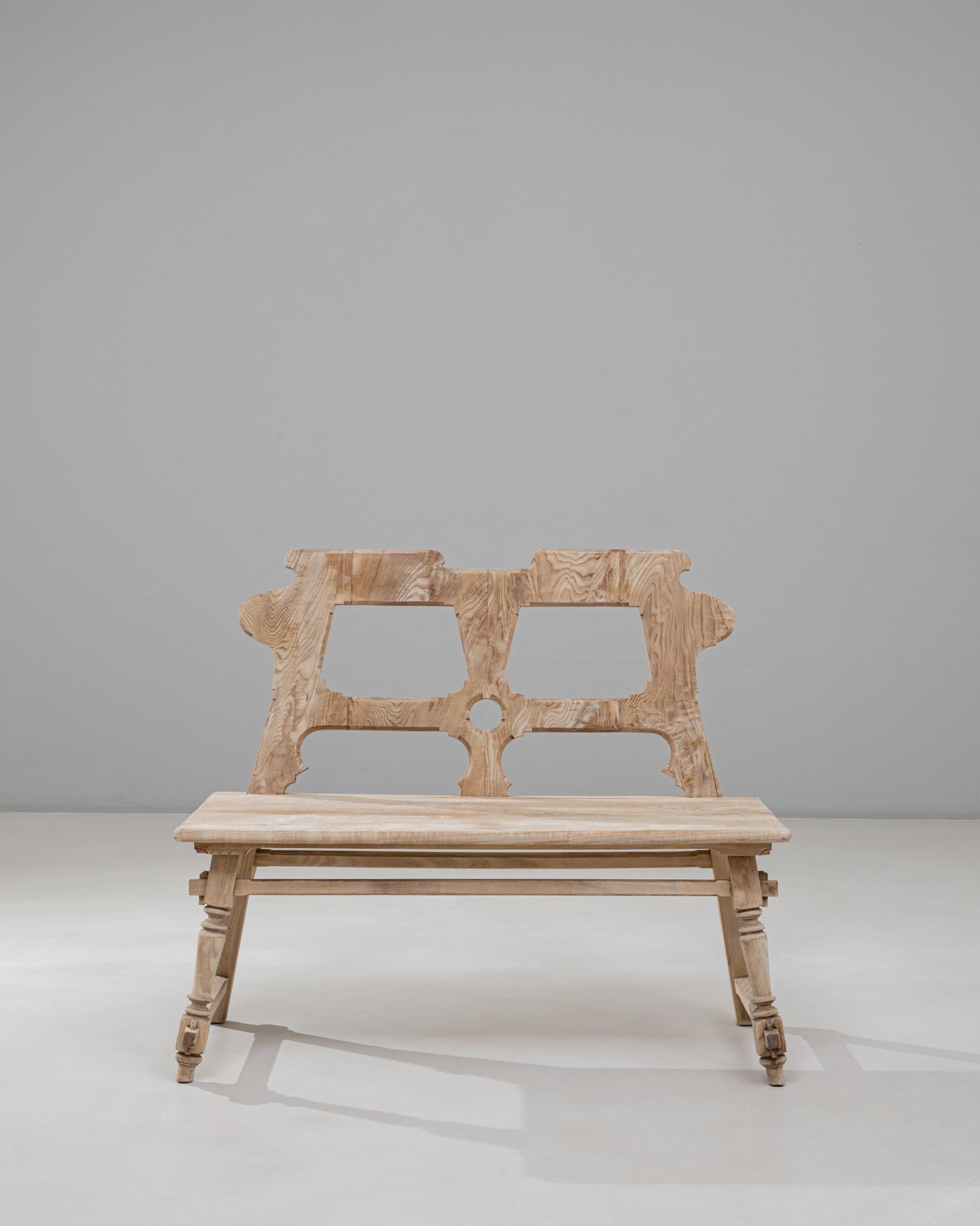 This 20th Century Austrian Alpine wooden bench features a distinctive sculptural backrest and a beautifully textured, lightly bleached finish characteristic of regional alpine craftsmanship. The backrest showcases bold cut-out motifs and organic