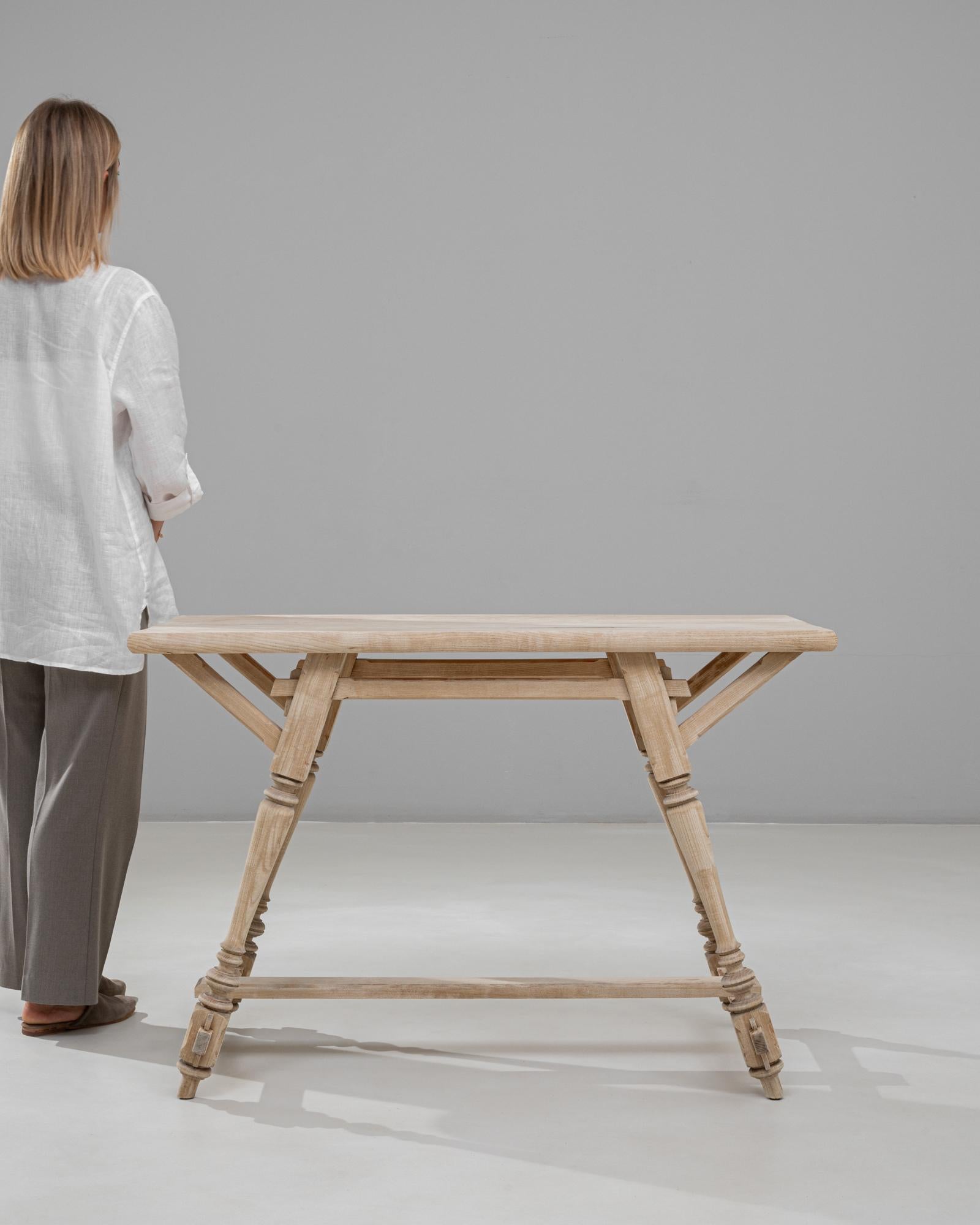 This 20th Century Austrian Alpine wooden console table showcases the charming craftsmanship and regional character associated with Alpine furniture traditions. Its distinctive silhouette is defined by angular supports, turned legs, and precisely