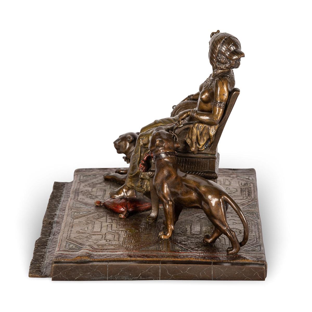 Bronze ancien autrichien du début du 20e siècle, peint à froid, représentant la reine Cléopâtre assise avec deux pumas à ses côtés, sur un tapis au modelé réaliste, drapé sur une base rectangulaire. Réalisé par Franz Xavier Bergman (1861-1936), sans