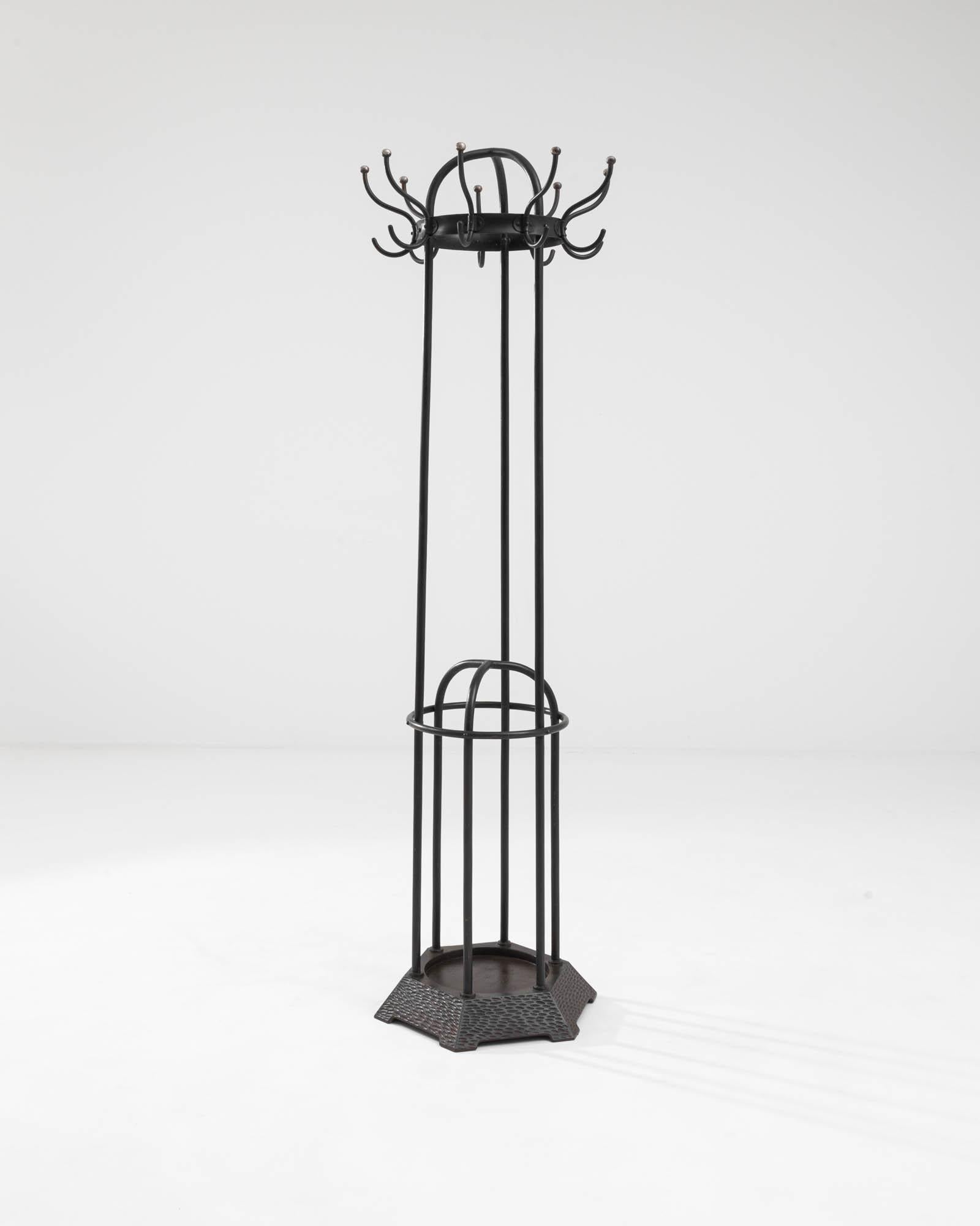 A metal free-standing coat hanger created in 20th century Austria. Created entirely from welded metal, this elaborate floor hanger imparts a neo-gothic style, creating a dark and brooding, yet oddly fascinating aura. Delicately bent tubes wind down