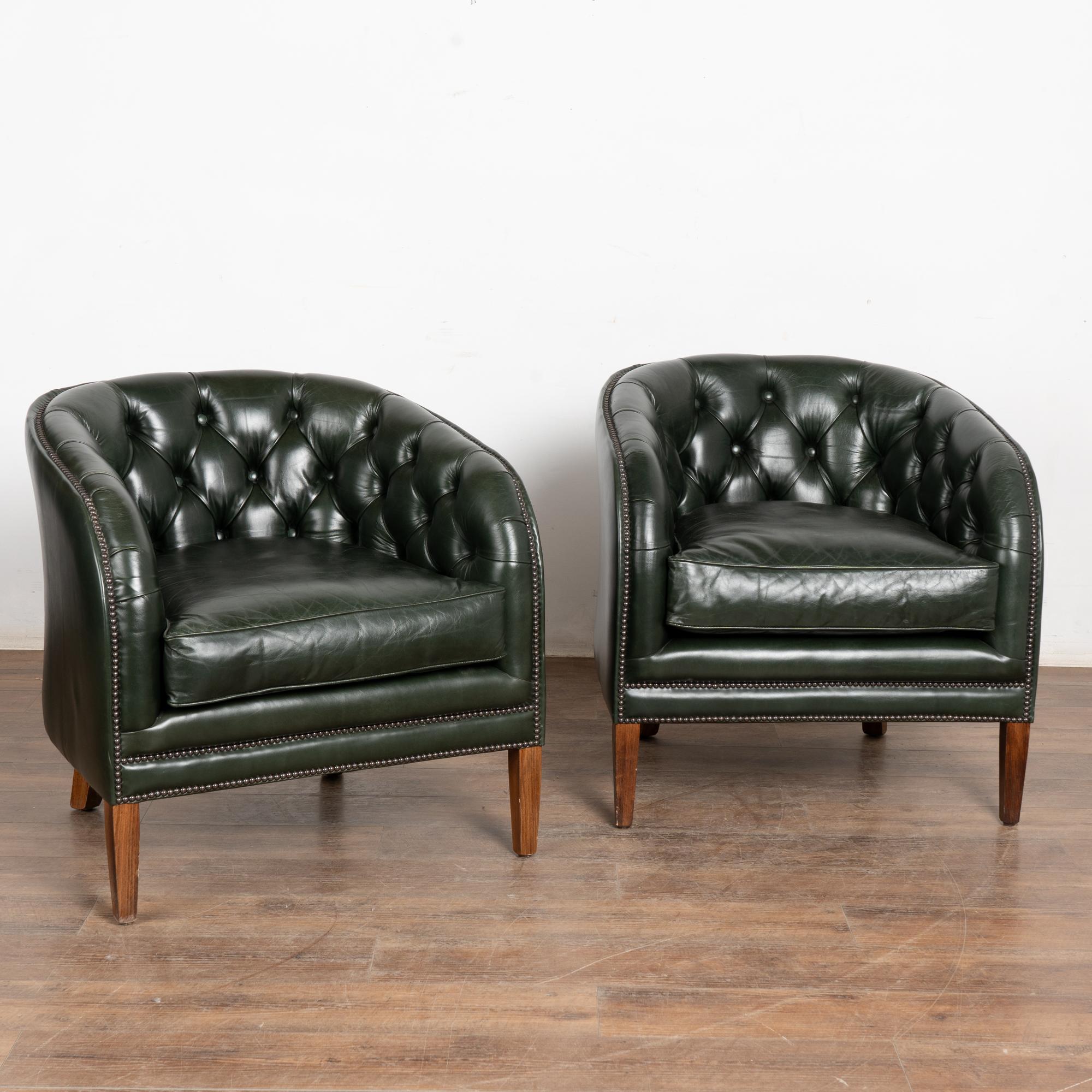 Questa autentica coppia di poltrone club in pelle verde di Chesterfield è caratterizzata da braccioli a forma di barile con decorazioni in testa di chiodo, schienali con bottoni e profili rivestiti.
Il marchio del produttore Chesterfield è visibile