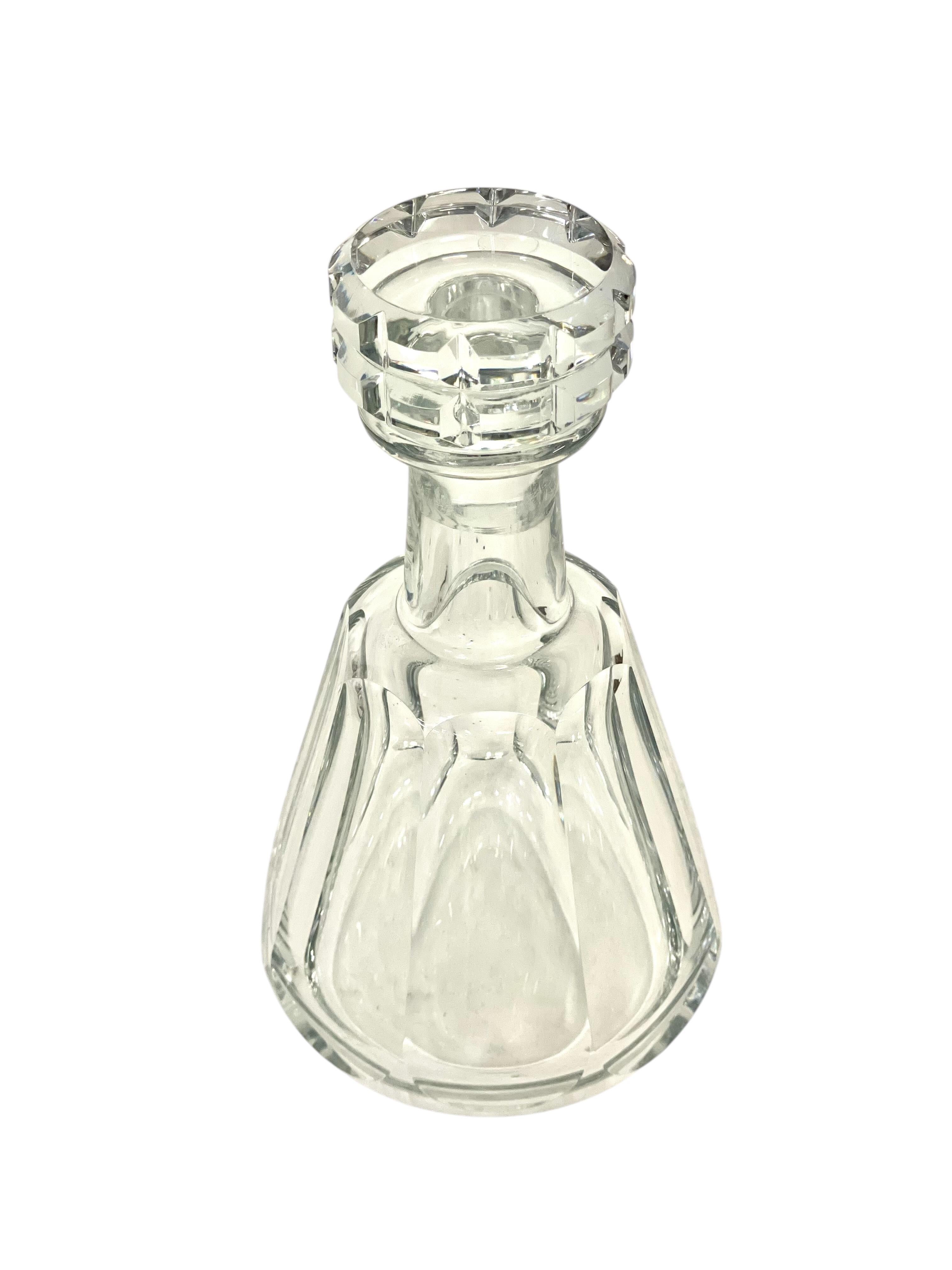 Este exquisito decantador de cristal es una pieza auténtica elaborada por la renombrada cristalería Baccarat, que data del siglo XX. Haciendo gala de una artesanía excepcional, este decantador presenta una silueta cónica atemporal adornada con