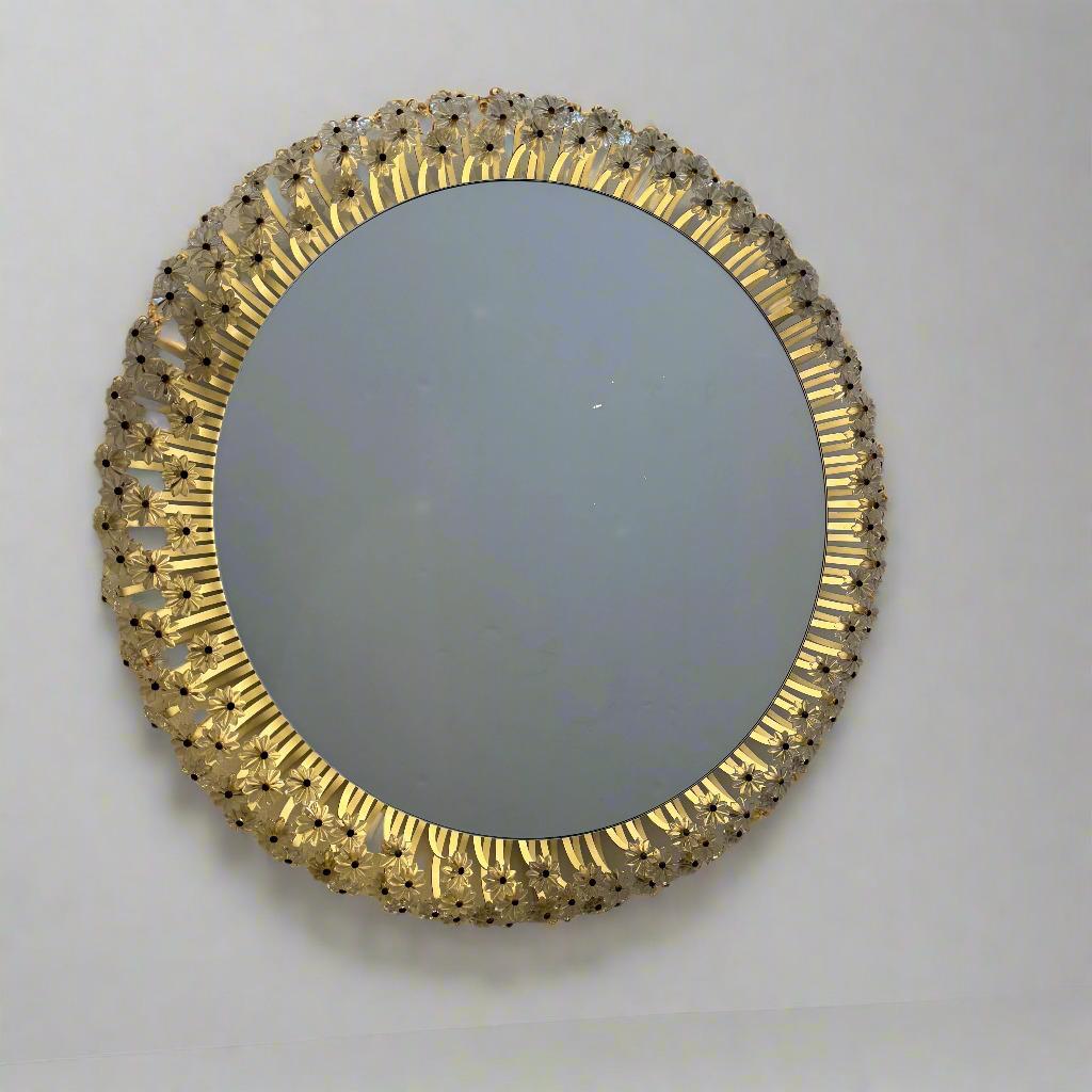 Un miroir circulaire moderniste rétro-éclairé entouré de rangées de rosettes lumineuses en lucite.