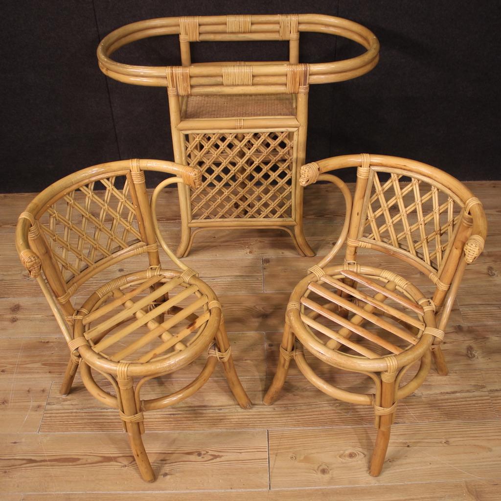 Particular set of Italian furniture from the 70s. Triptych consisting of a table and two interlocking chairs in bamboo wood, woven wood and rattan with a beautiful line and pleasant furnishings. Oval coffe table, missing glass top (see photo),