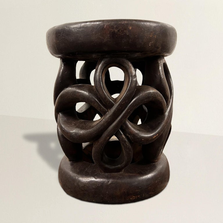 A bold and lively 20th century Bamileke stool hand-carved of one piece of wood with a wonderful knot pattern, and with a rich patina that only time can bestow. The stool can also double as a side table next to your favorite armchair.
