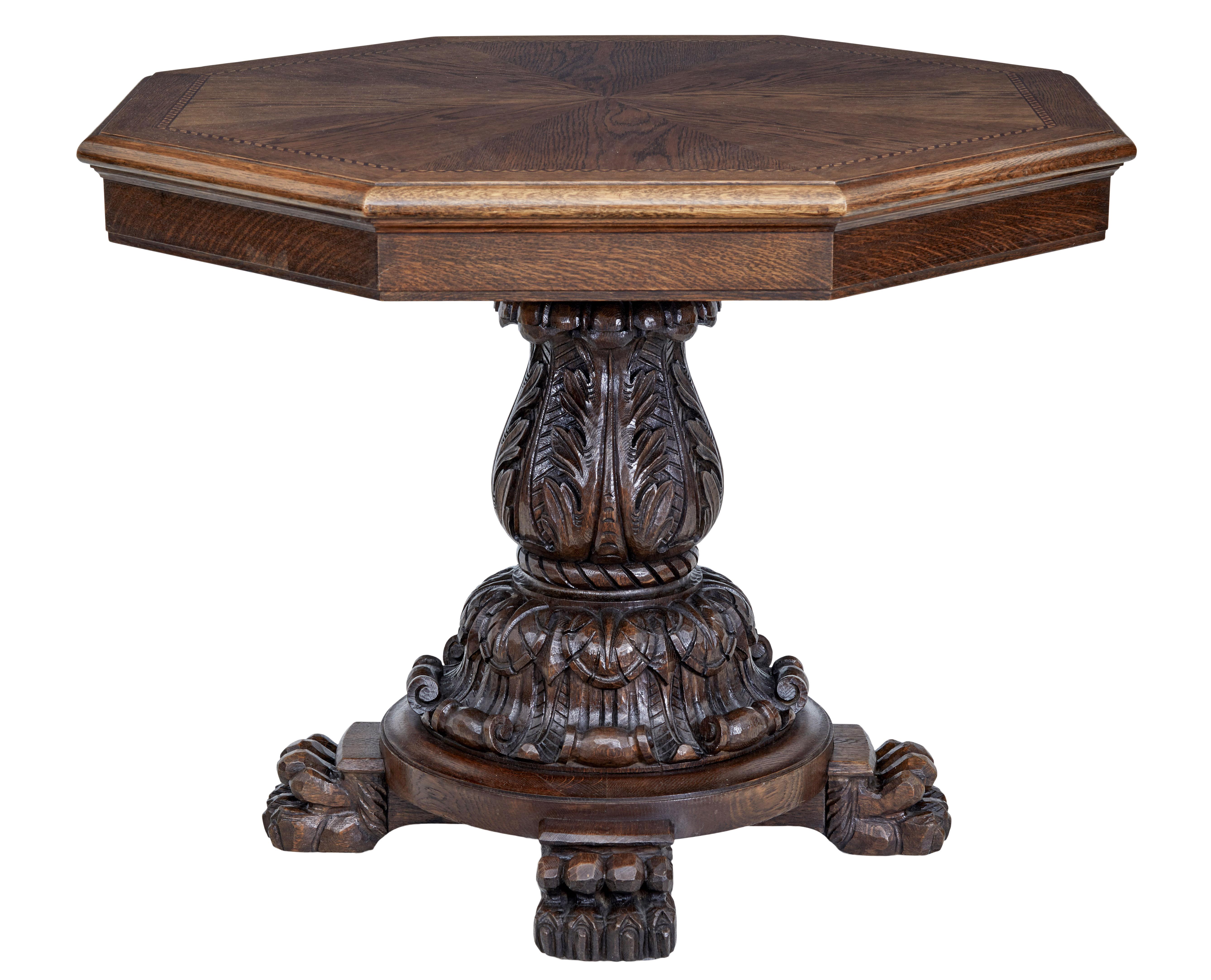 20th century baroque influenced oak center table circa 1930.

Octagonal top with segmented oak veneers, inlaid border of birch and mahogany and a further oak border. Supported by a heavily carved stem base with acanthus leaf