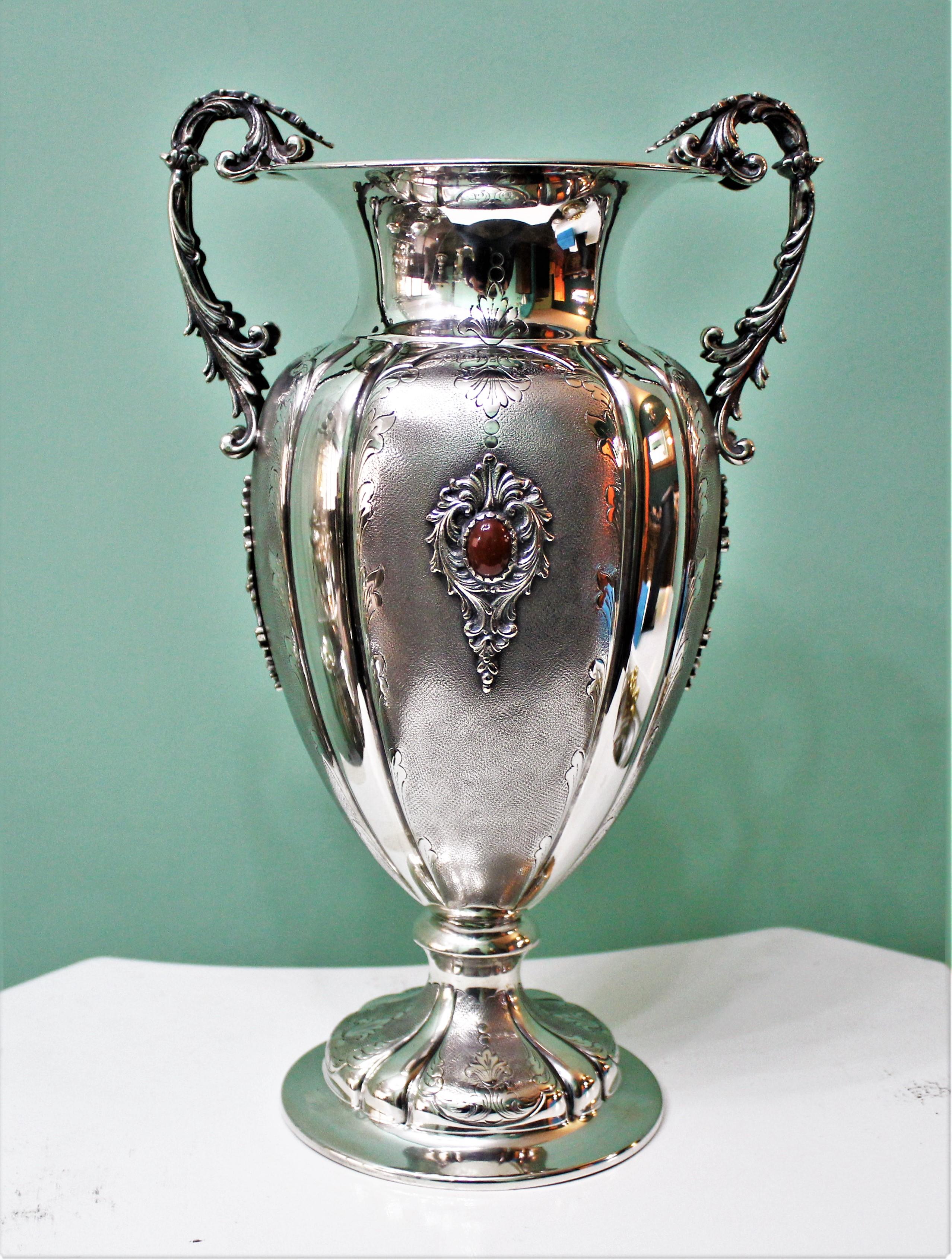 Silver Baroque flower vase embossed and engraved, with applications of semi-precious stones and cast acanthus leaf shaped handles. Size height 31.5, width 19 weight 860 gr.
Realized by an Italian silversmith from Milan, circa 1950s.
Very beautiful