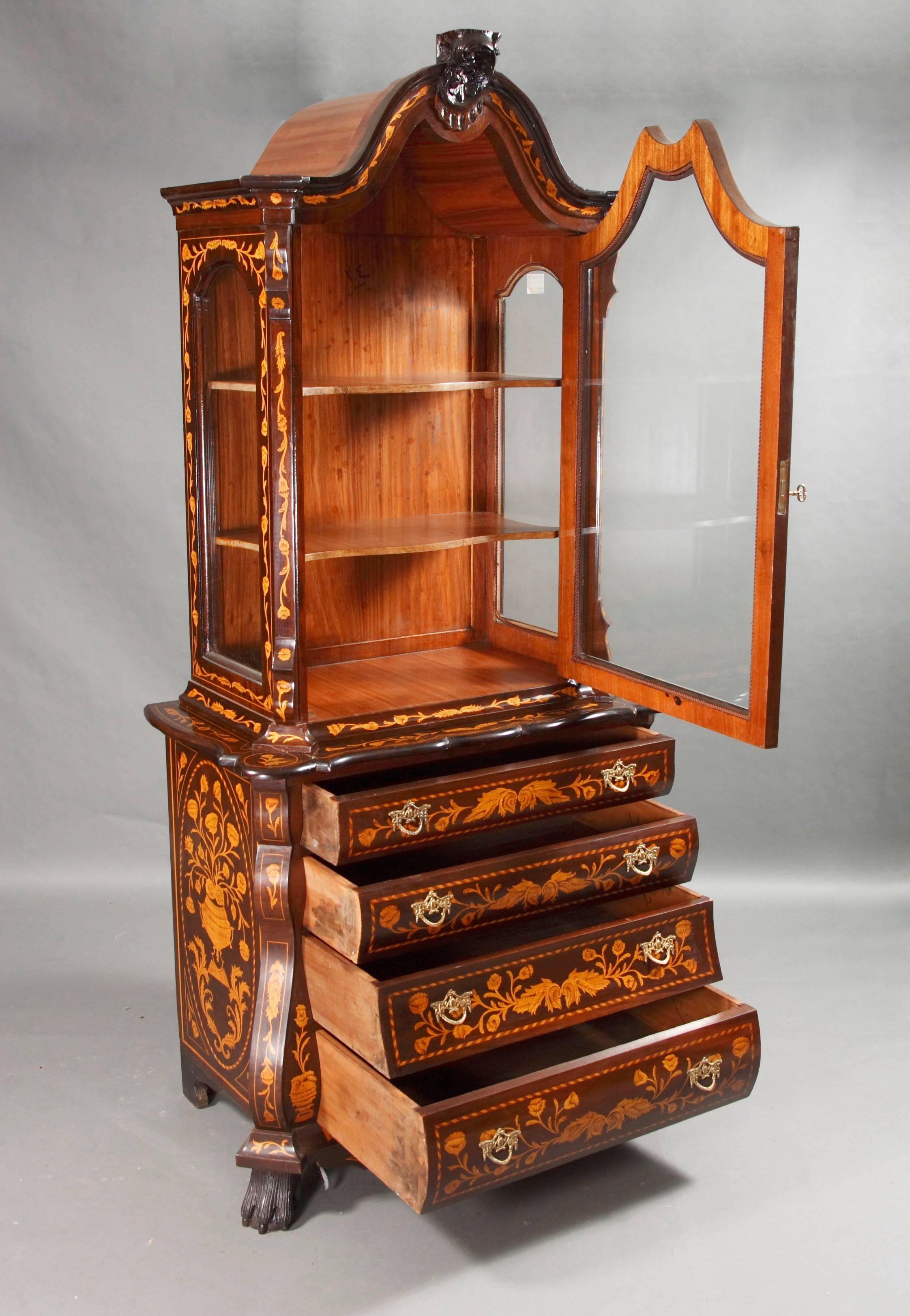 Display cabinet in Dutch Baroque style
Light mahogany and maple on solid wood. Exceptionally rich intarsia. Work on carved paw-feet. Multiple curved border above bowed four-drawered body, framed with prominent corner-pilaster strips. Multiple