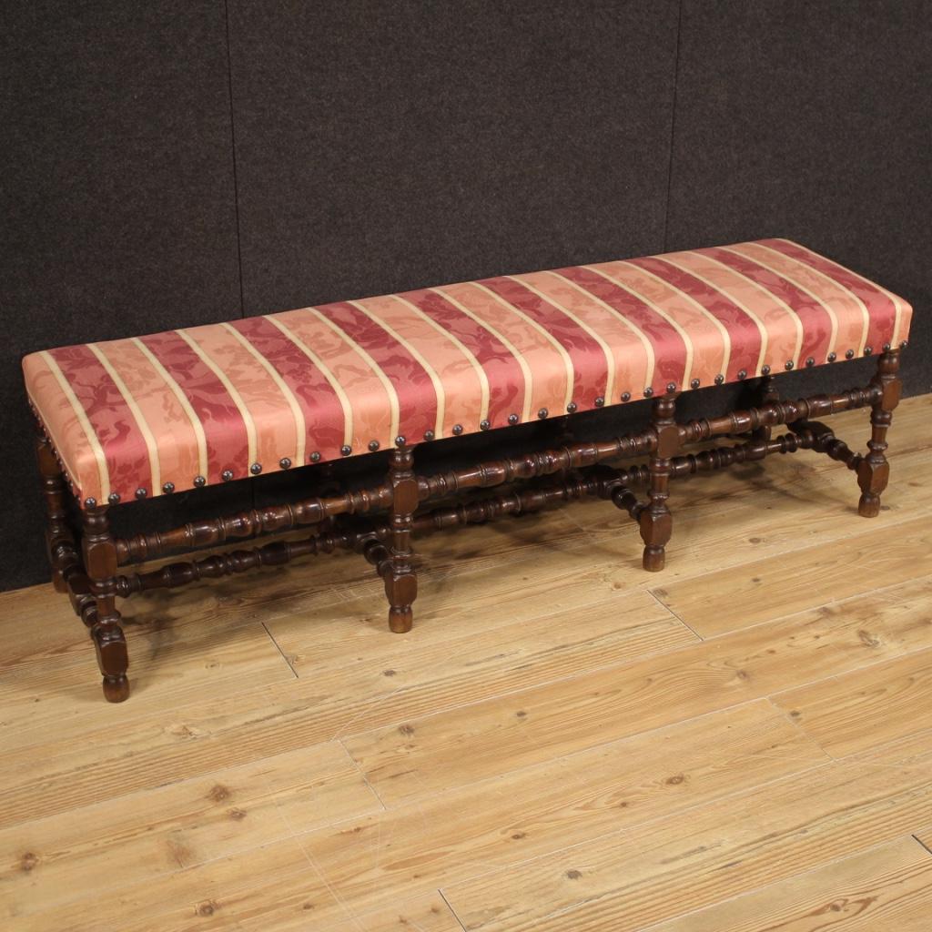 Italian bench from the mid-20th century. Furniture carved in walnut patinated beech wood of beautiful lines and pleasant decor. Seat upholstered in fabric (not original, replaced during the 20th century) in fair condition, without holes or tears but