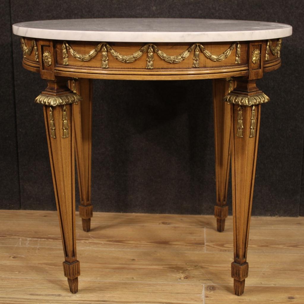 French coffee table from 20th century. Furniture carved in beechwood in Louis XVI style richly adorned with gilded and chiseled bronze and brass. Marble top, not original, replaced during the 20th century, in excellent condition. Table of good