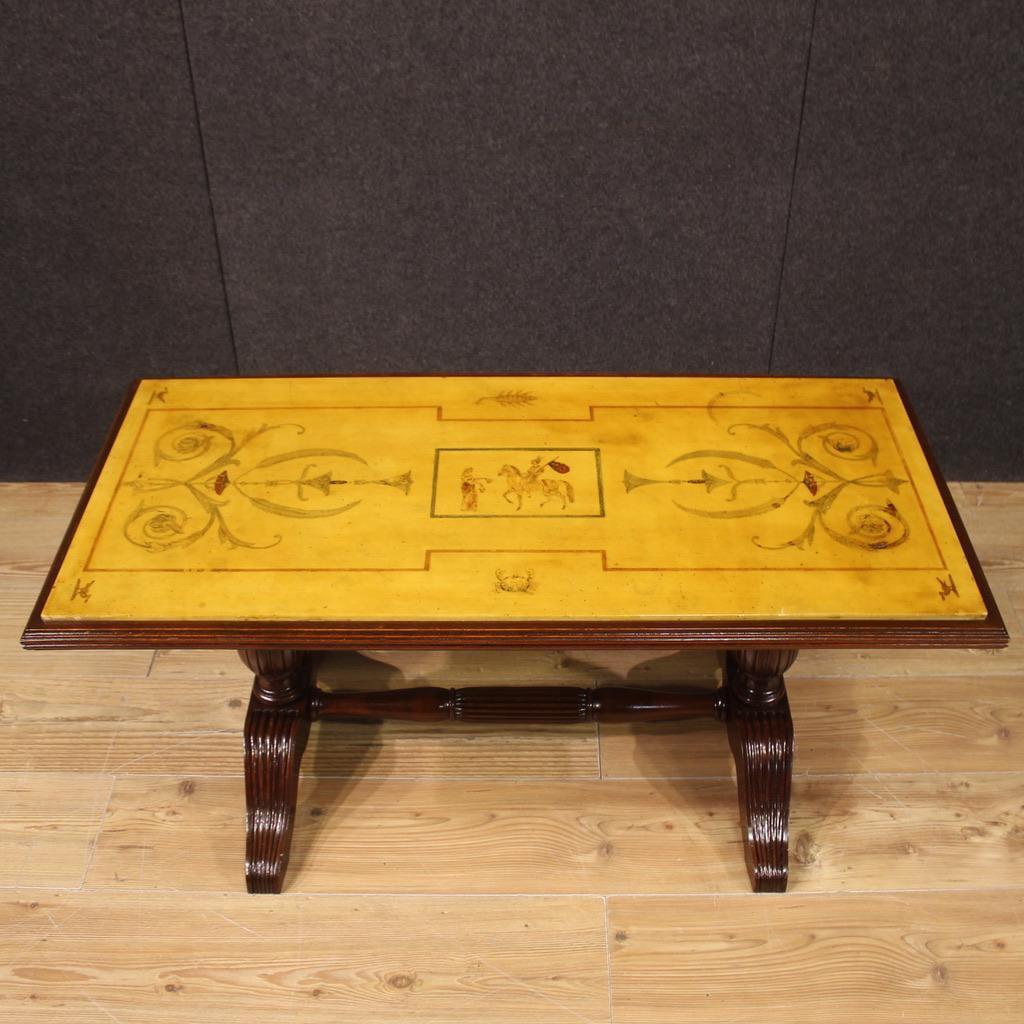 Elegant Italian coffee table from the 1960s. Furniture with carved beech wood base (mahogany color) and fabulous chiselled marble top, inlaid with plaster and painted with decorations, animals and figures in a neoclassical style. Coffee table of