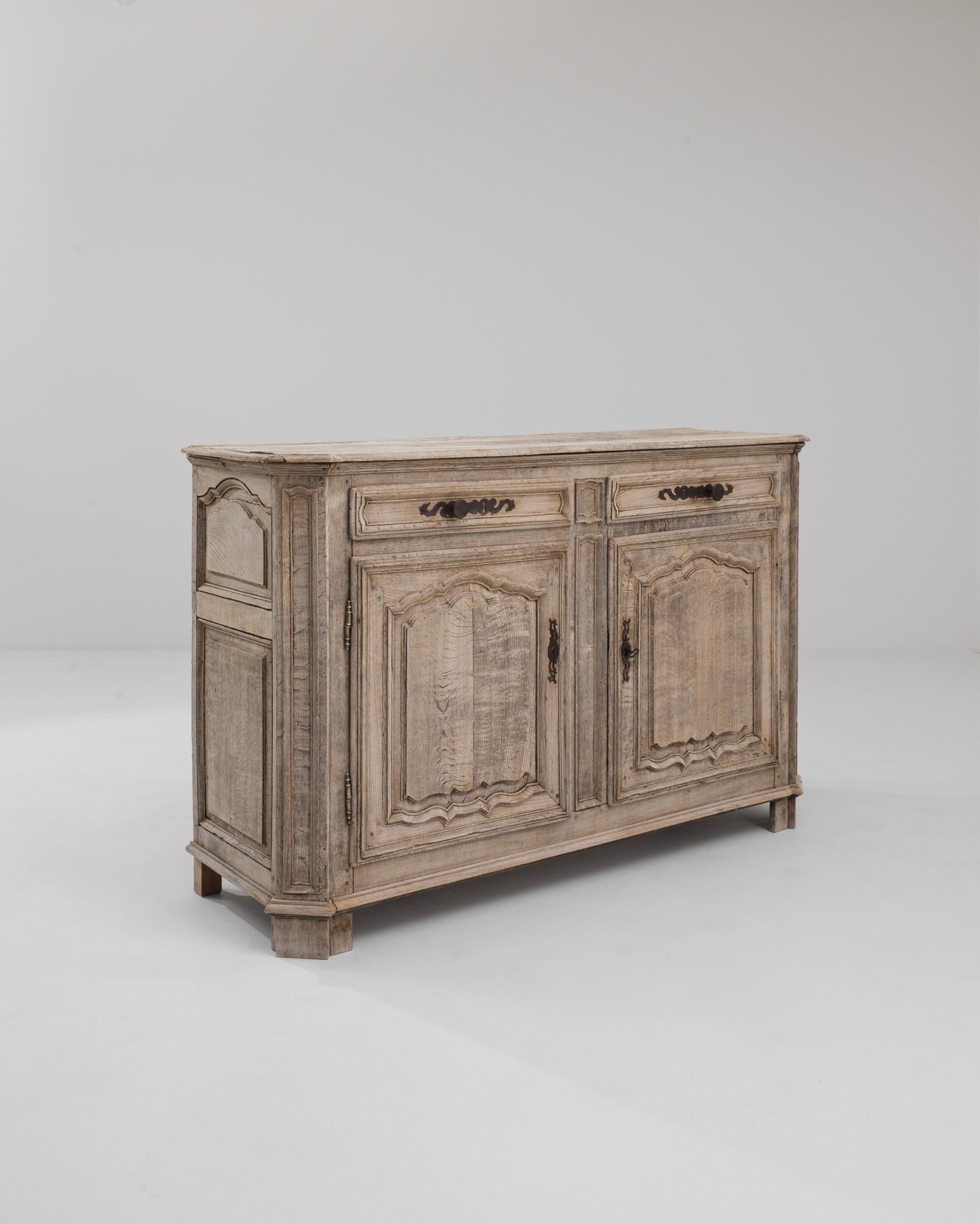 A wooden buffet made in 20th century Belgium. This large buffet features two doors and two drawers. The oak has been carefully refinished to protect the wood surface and also bring fresh luster to the natural material. The lightly patinated oak