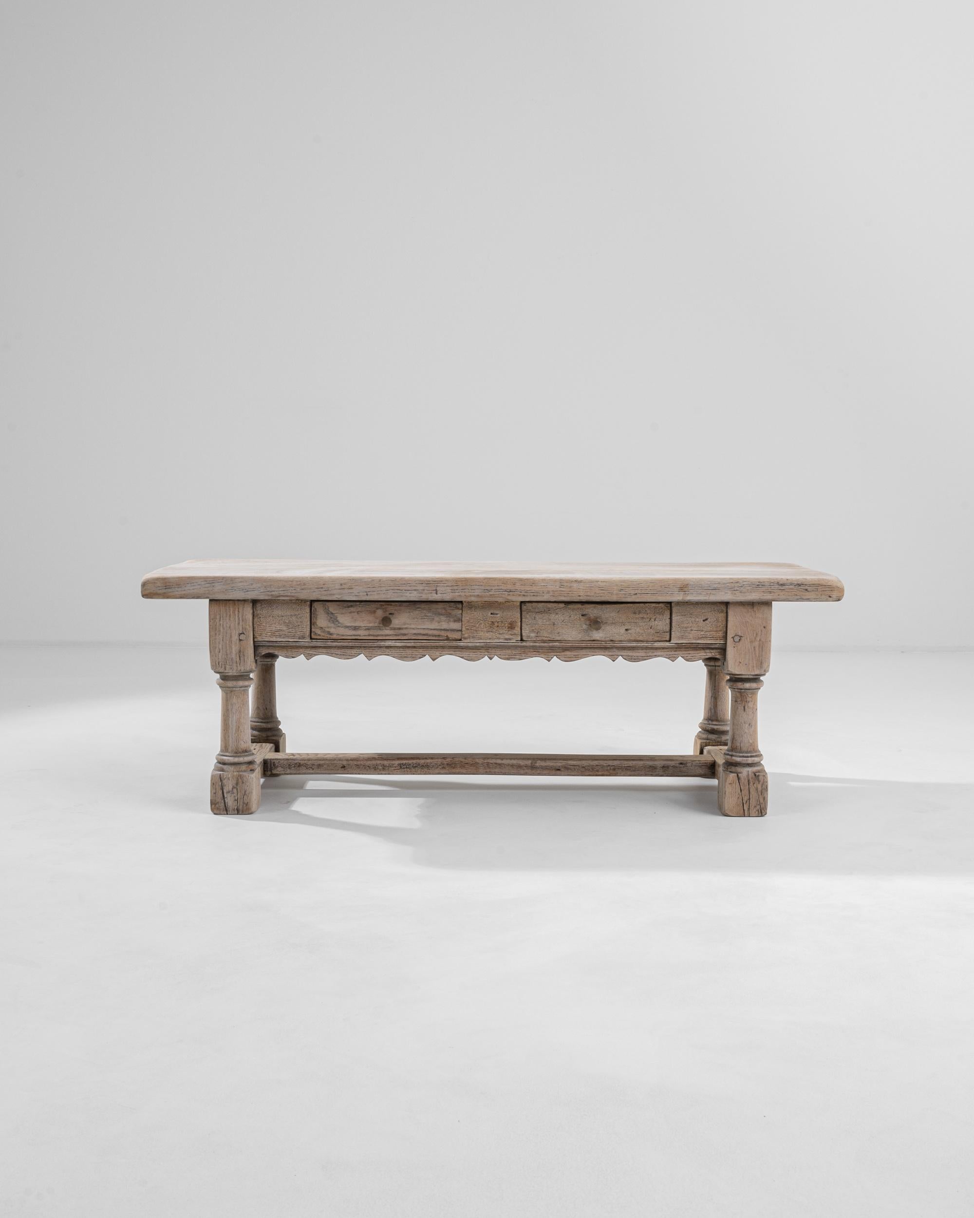 This Provincial oak coffee table evokes the pleasures of hearth and home. Made in Belgium in the 20th century, the design recreates the farmhouse tables of country households in miniature. A solid tabletop sits atop legs carved into the shape of