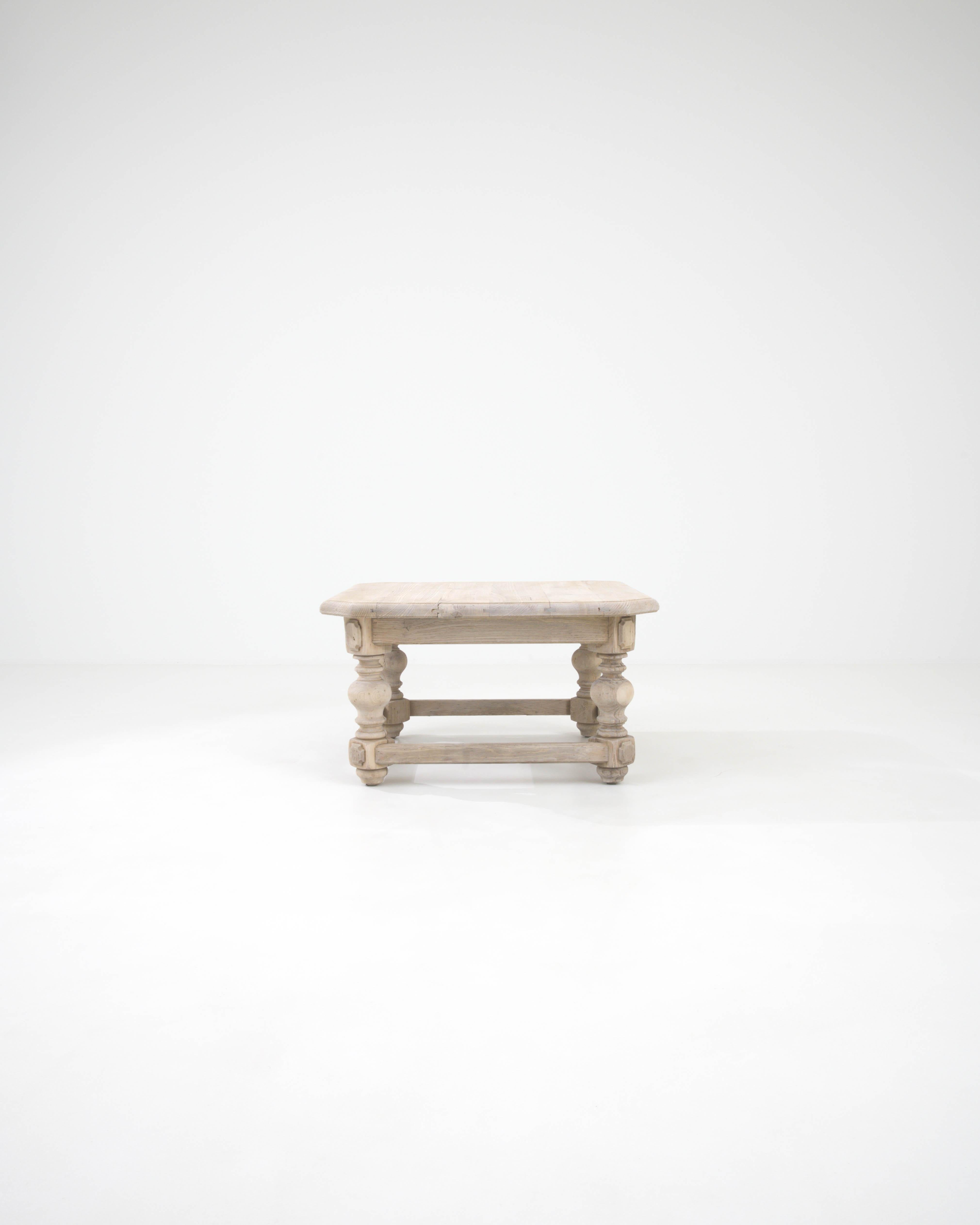 Découvrez l'incarnation de l'élégance discrète avec cette table basse en chêne blanchi belge du 20e siècle. Chaque ligne et chaque courbe sont soigneusement élaborées, ce qui donne un design solide et robuste qui invite à se rassembler autour pour