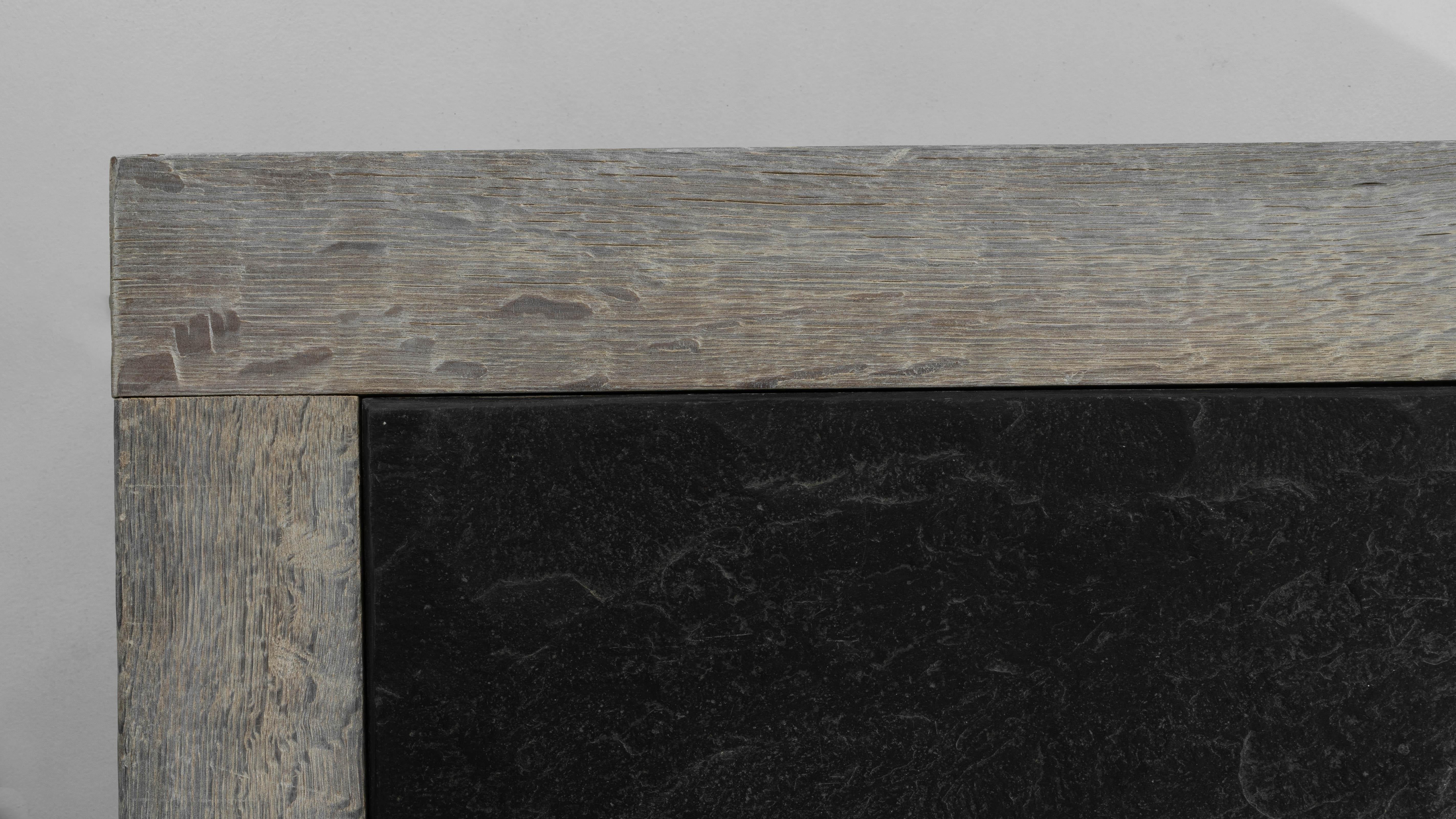 Cette exquise table basse belge du XXe siècle allie charme rustique et fonctionnalité raffinée. Fabriquée en chêne blanchi, la table présente une belle patine d'usage qui lui confère caractère et chaleur. Le plateau présente une incrustation de
