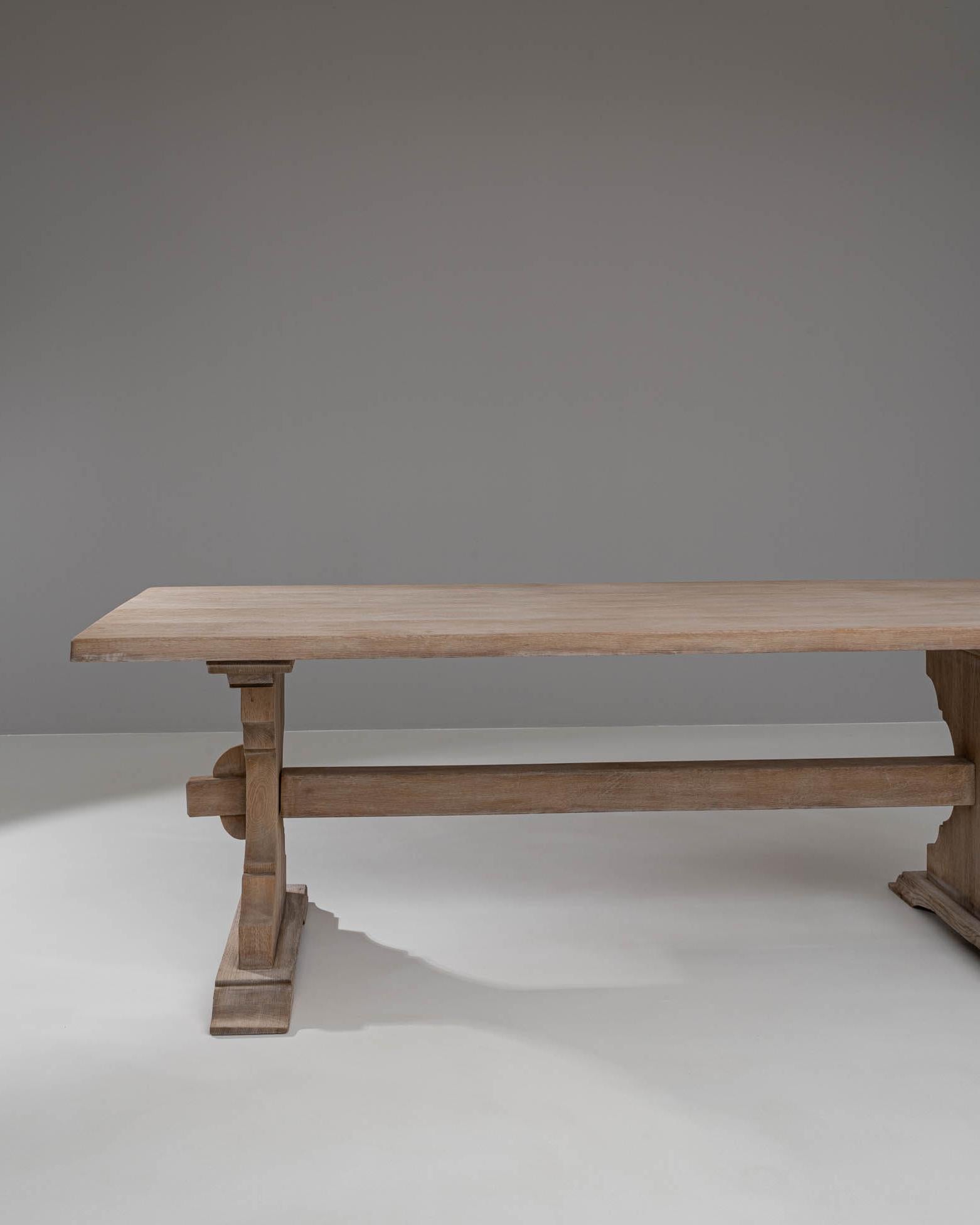 Esta mesa de comedor de roble blanqueado belga del siglo XX personifica la elegancia atemporal con su diseño robusto y refinado. Fabricada en roble de alta calidad, la mesa presenta un bonito acabado blanqueado que resalta las vetas naturales y la