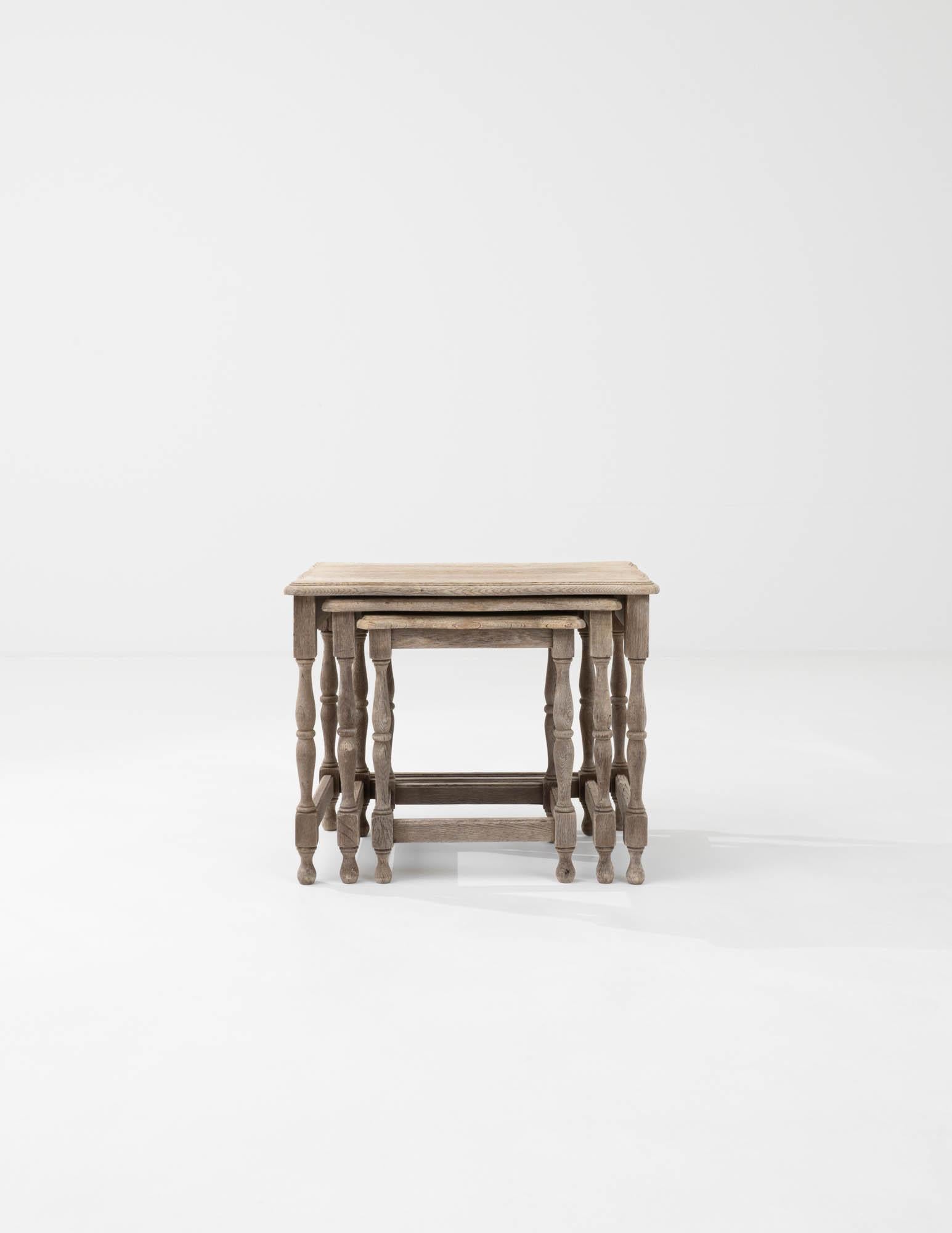 Introduce the charm of versatile design into your home with this set of three 20th Century Belgian Bleached Oak Nesting Tables. Each table is a marvel of classic craftsmanship, featuring the light and airy finish of bleached oak that evokes a sense