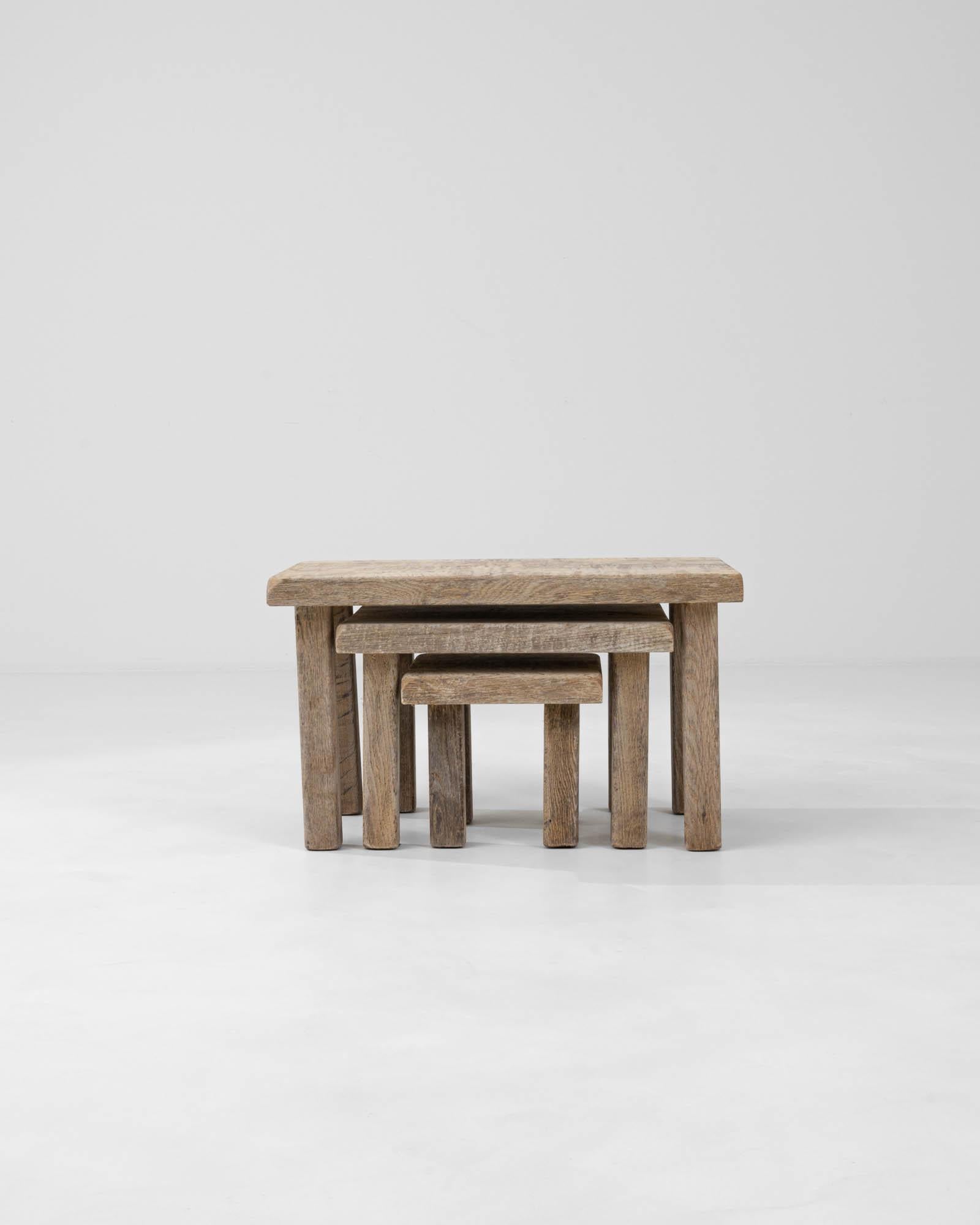Discover the epitome of functional elegance with this set of three 20th Century Belgian Bleached Oak Nesting Tables. Each piece in this trio features a beautiful, weathered finish that highlights the unique grain and character of bleached oak.
